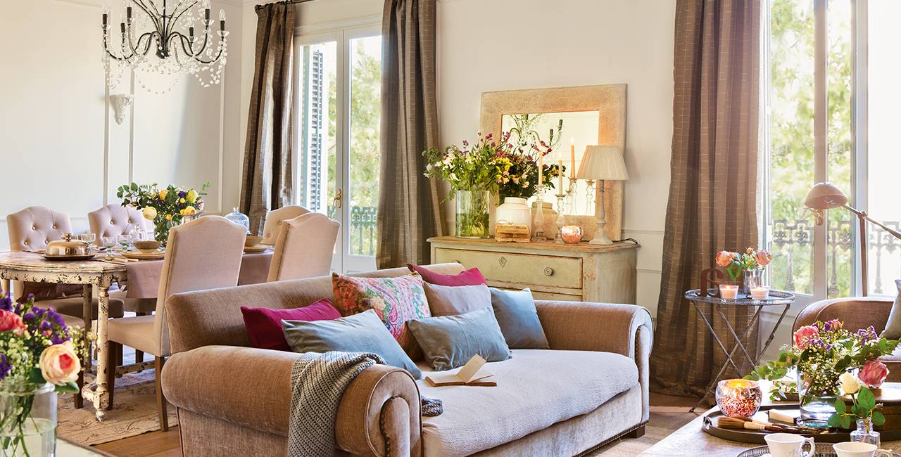 Salón otoñal con sofá de terciopelo y jarrones de flores