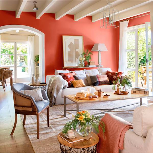 Salón tonos rojos con suelos de madera que calientan la casa en otoño