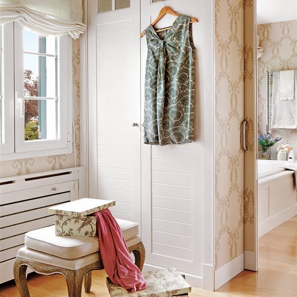 Zona de vestidor con armario empotrado y papel pintado