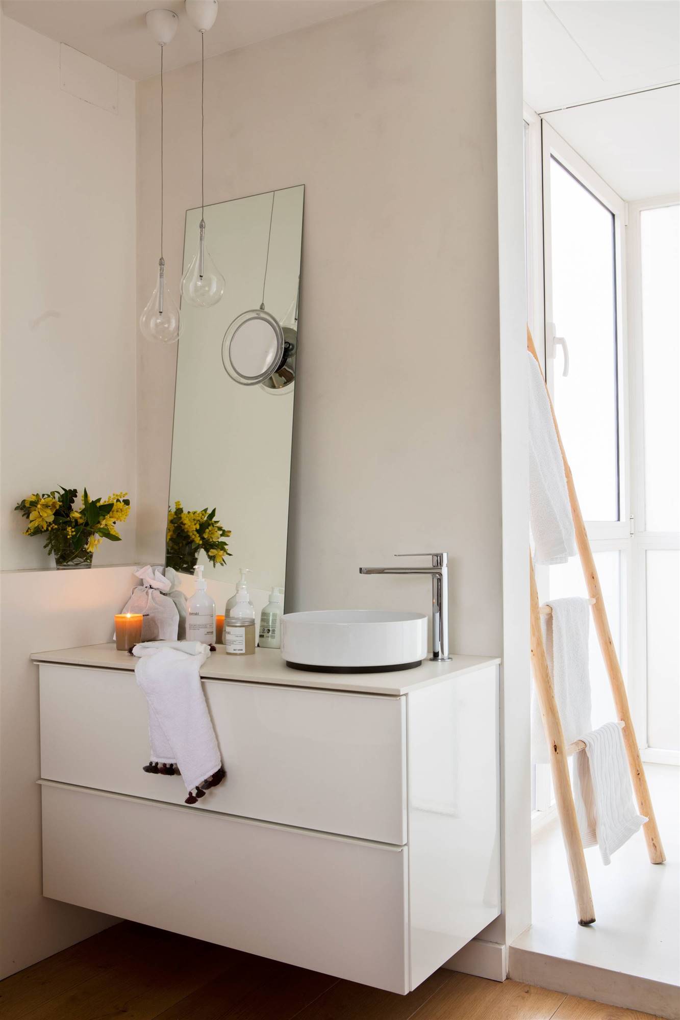 Baño moderno con mueble blanco y espejo apoyado. 