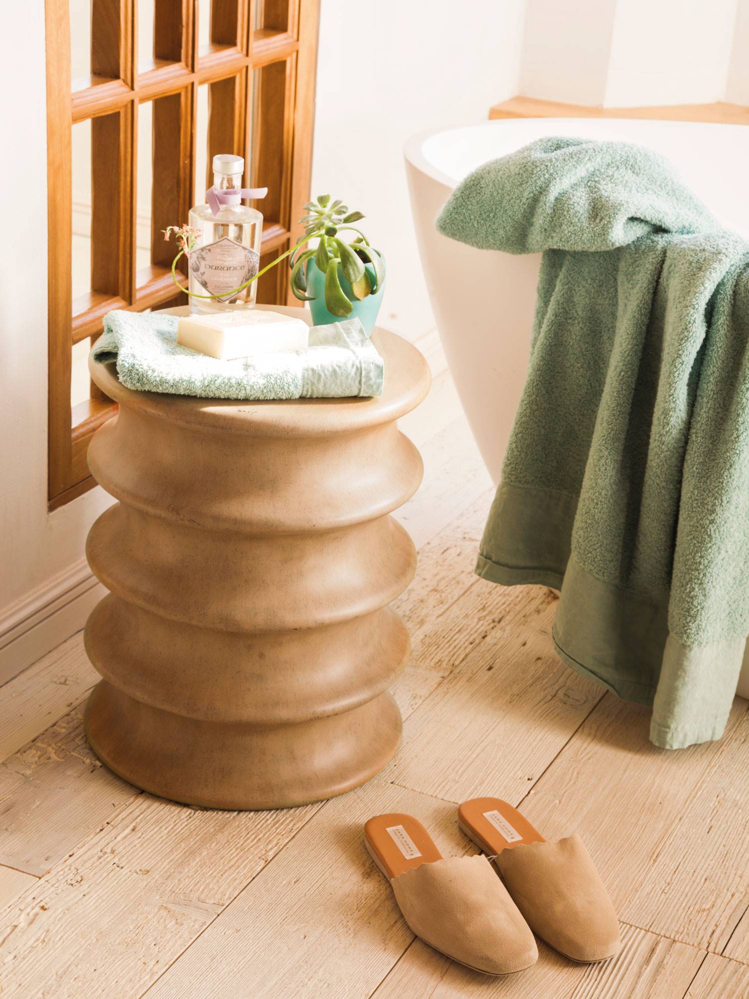 Baño con detalle decorativo para poner toallas, perfumes y una pequeña planta.