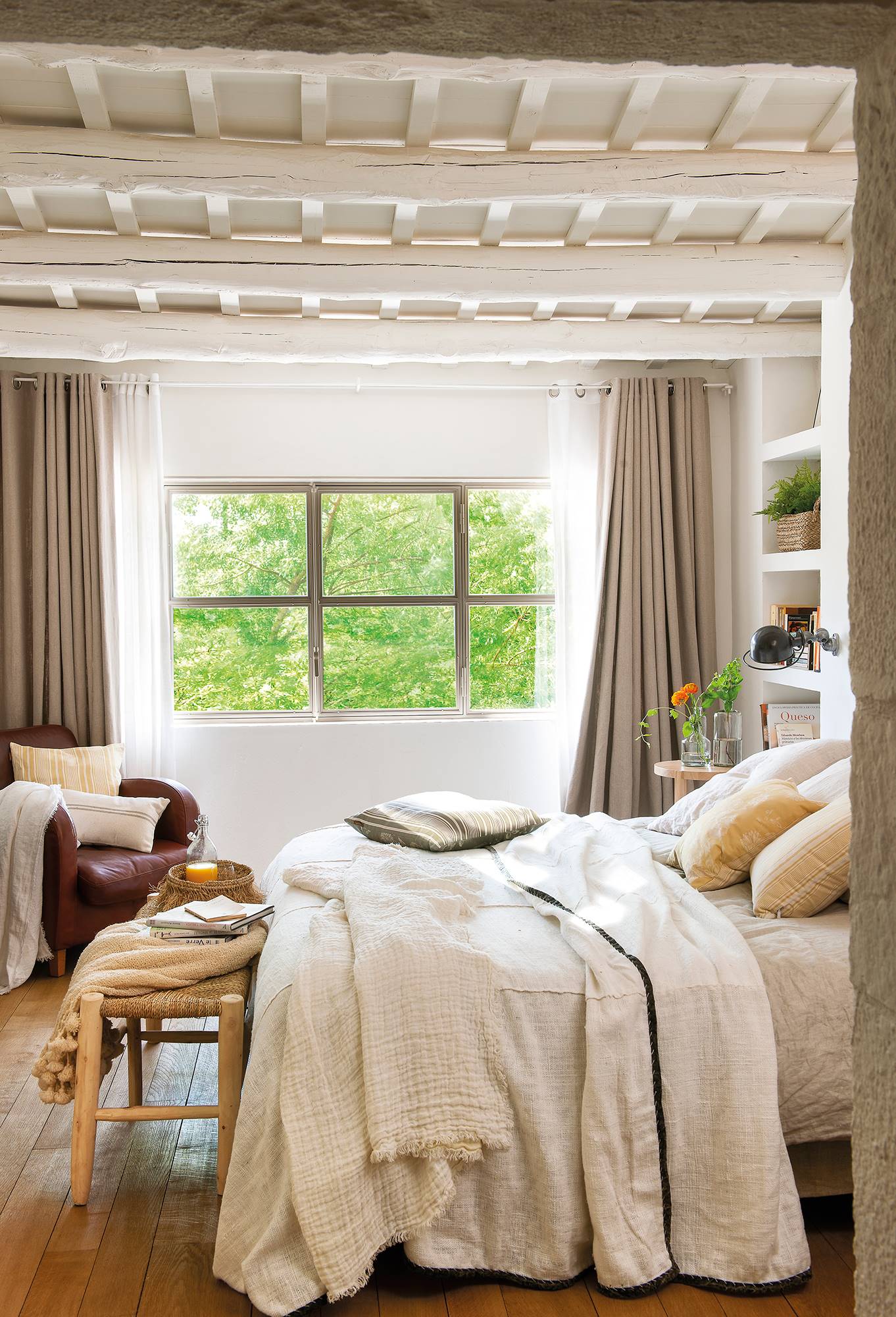 Dormitorio de primavera en blanco con vigas de madera y cortinas en gris.