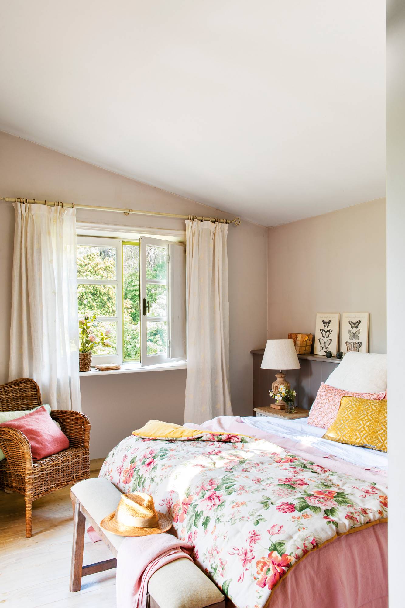 Dormitorio de primavera con ropa de cama estampada y butaca de fibra.