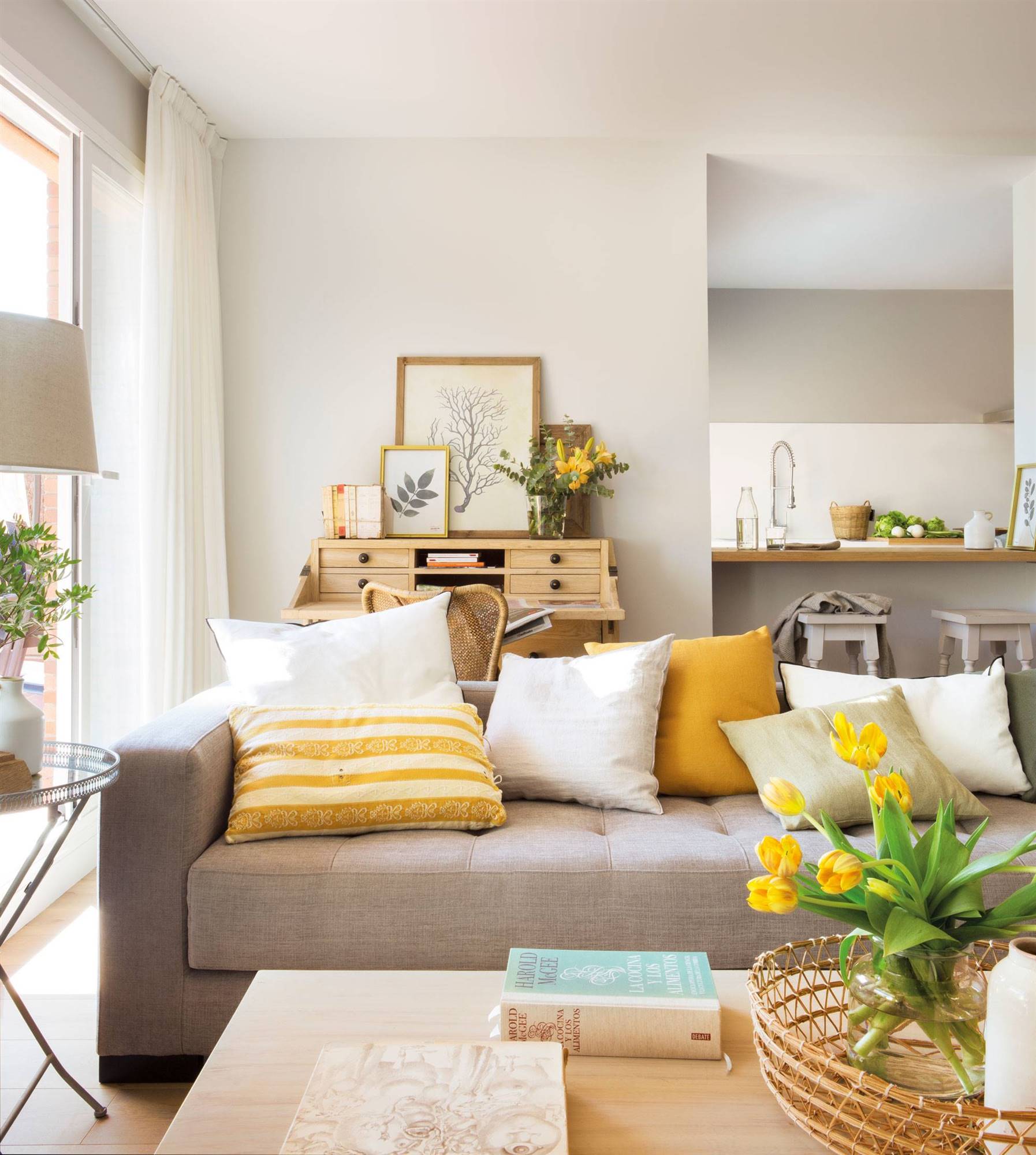 Salón de primavera con sofá gris y cojines amarillos.