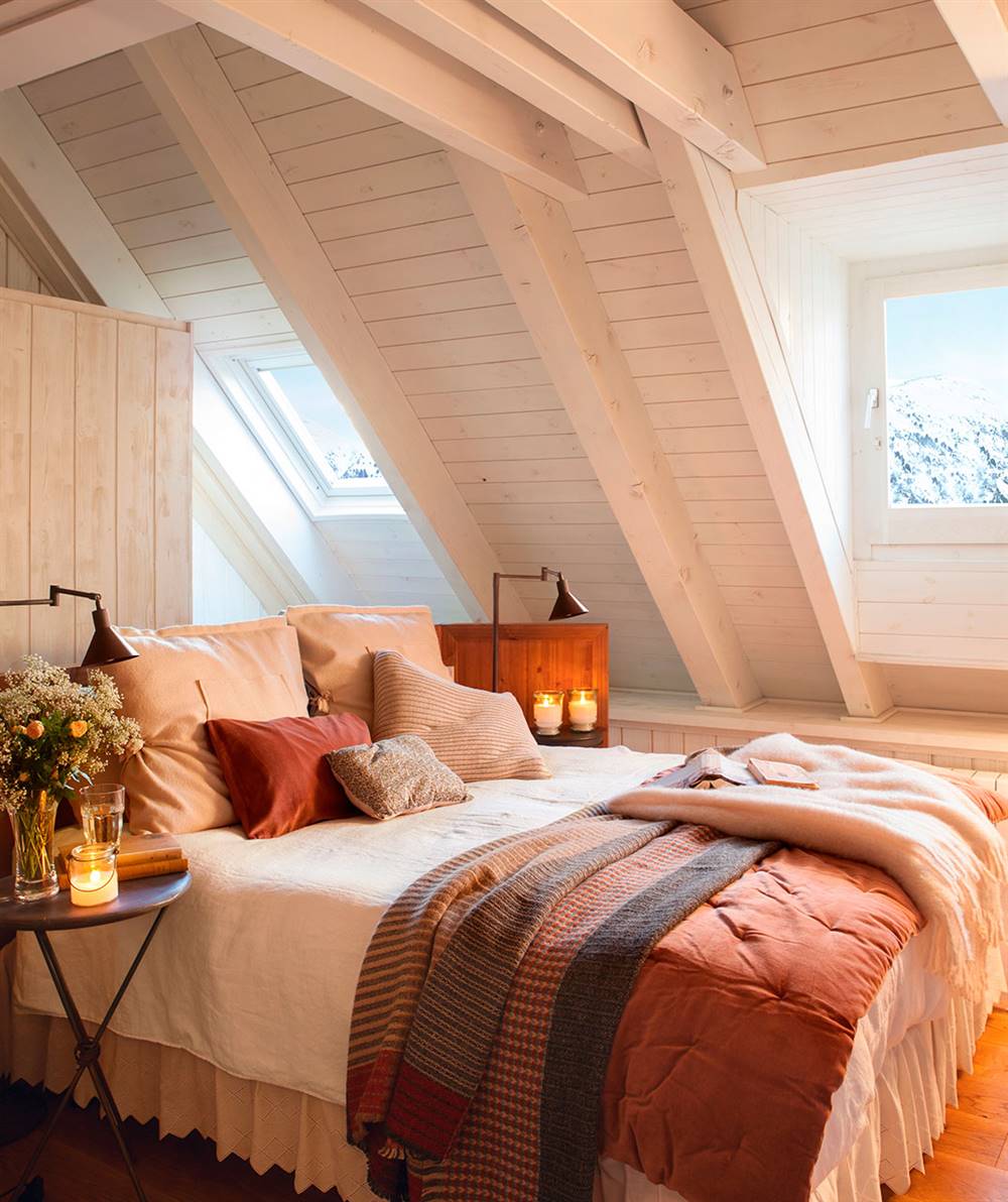 dormitorio-rustico-con-techo-abuhardillado-en-madera-blanca-y-cama-con-textiles-rojos
