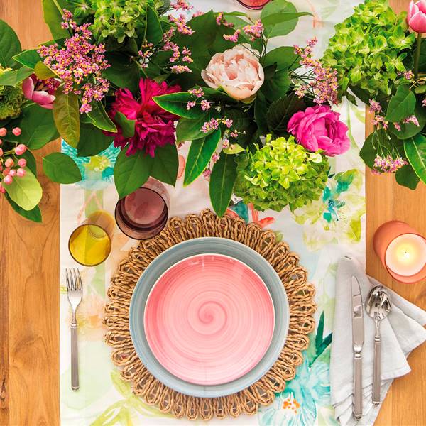 Mesa puesta con vajilla de colores, bajoplato de fibra, camino de mesa, centros de flores y velas