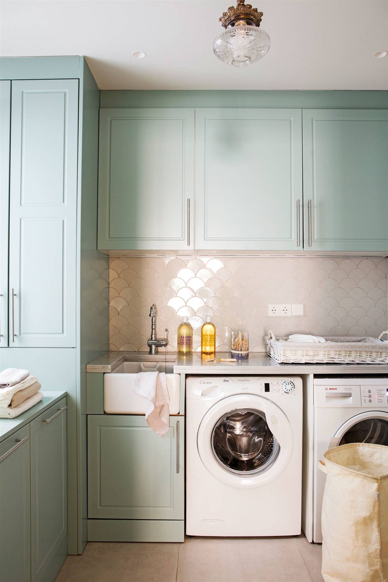 Cocina con azulejos blancos de concha y armarios pintados en color verde agua