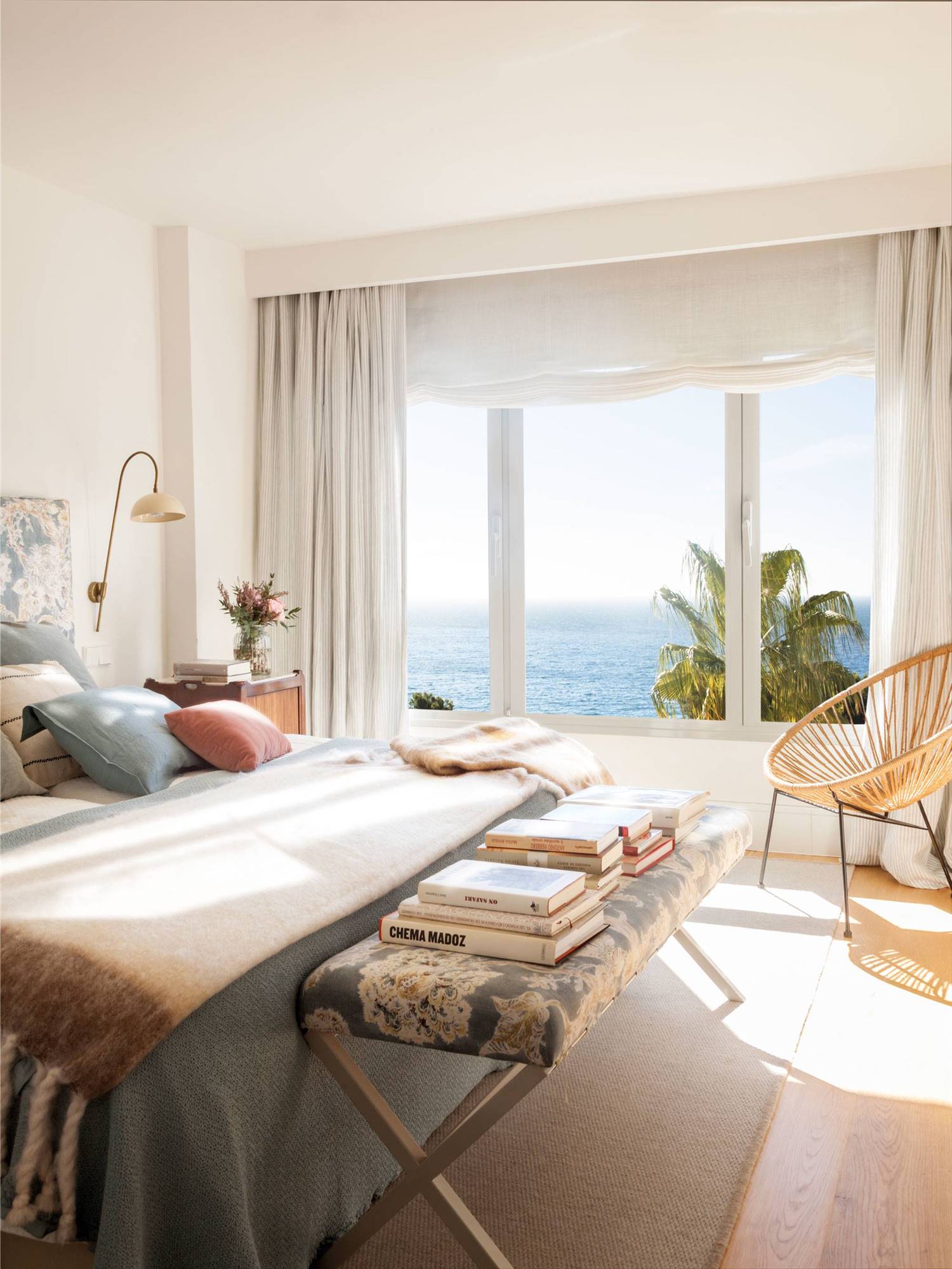Dormitorio con gran ventanal con vistar al mar y cabecero tapizado 