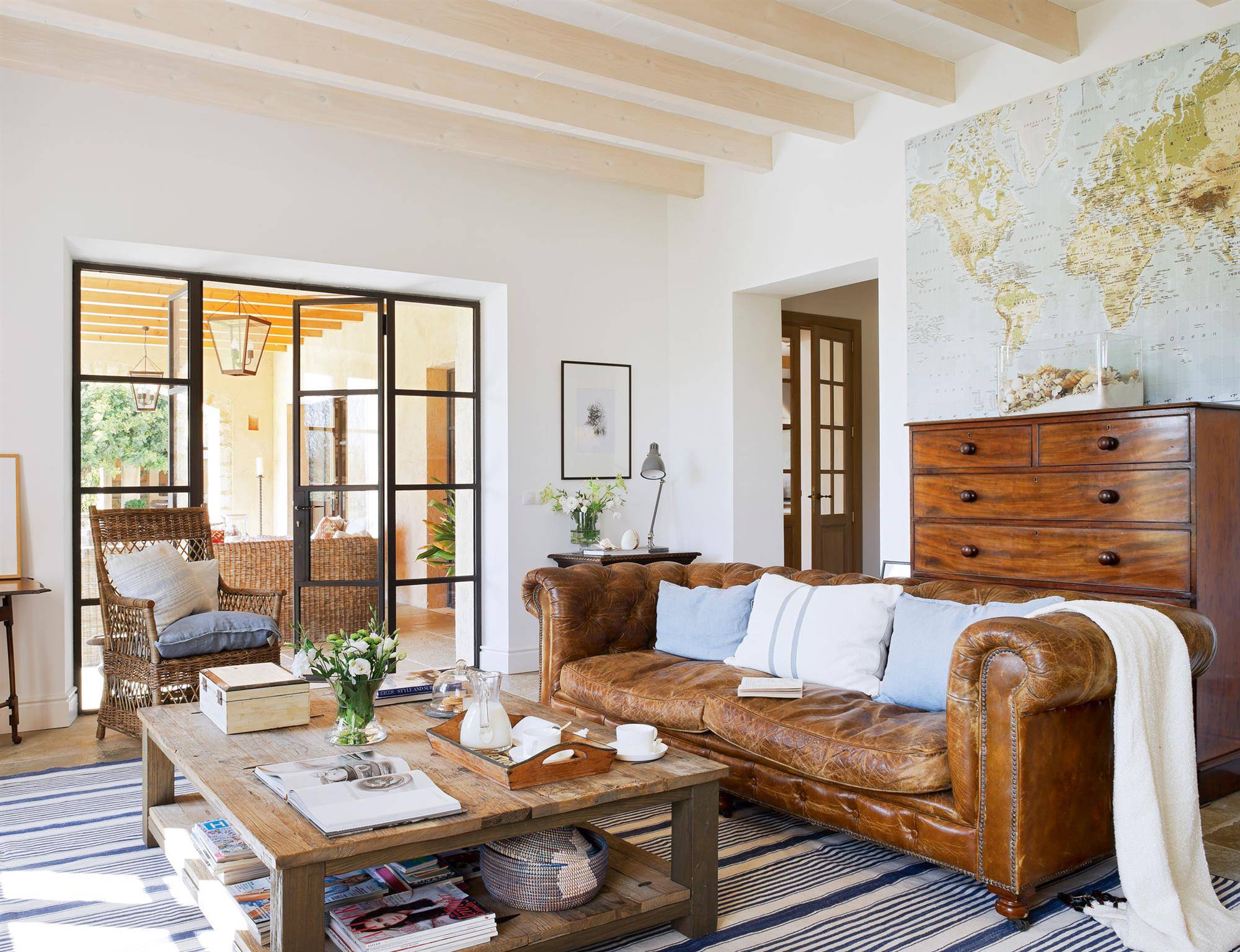 Salón vintage con sofá chéster de cuero y muebles de madera.  