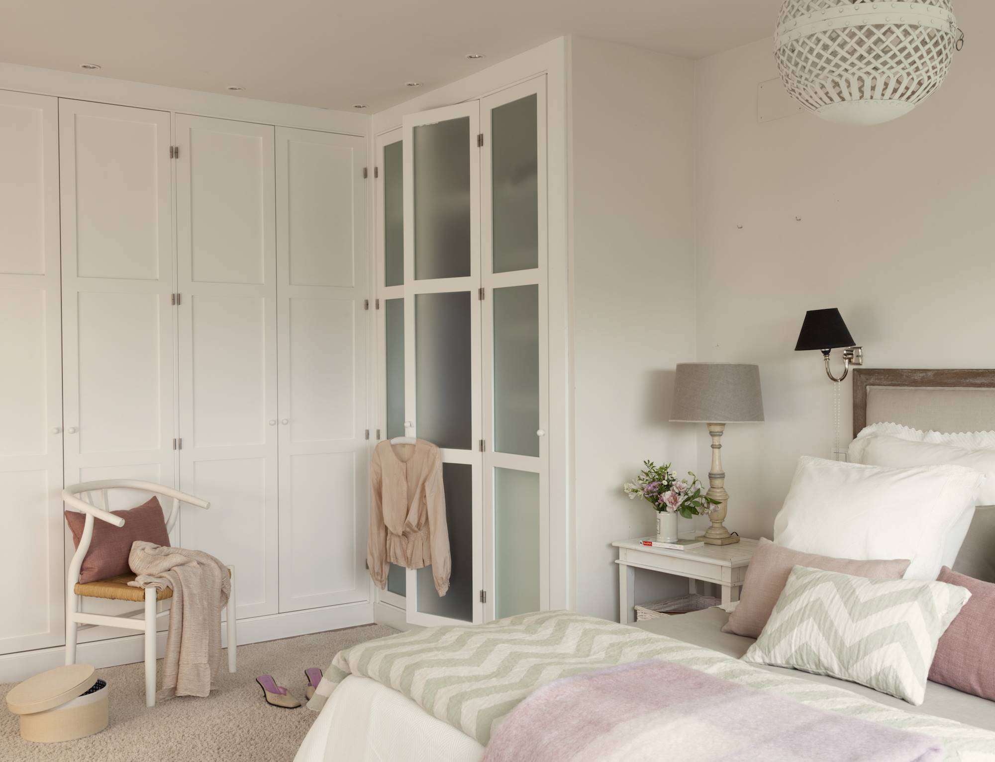 Dormitorio con armarios blancos con frentes ciegos y acristalados