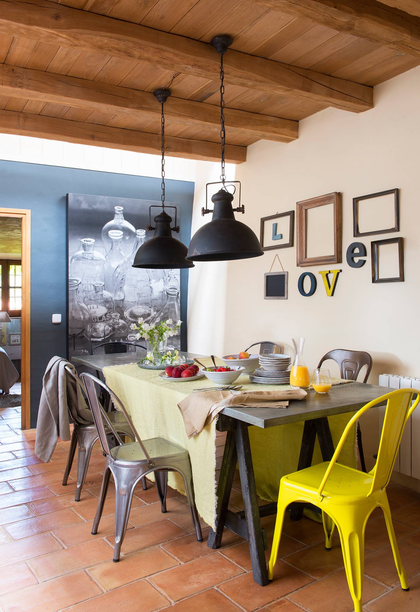 Comedor con muebles de aire industrial con pared decorada con letras.