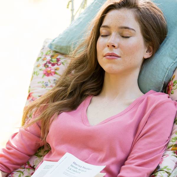 Mujer durmiendo la siesta en la hamaca con libro en las manos-457535