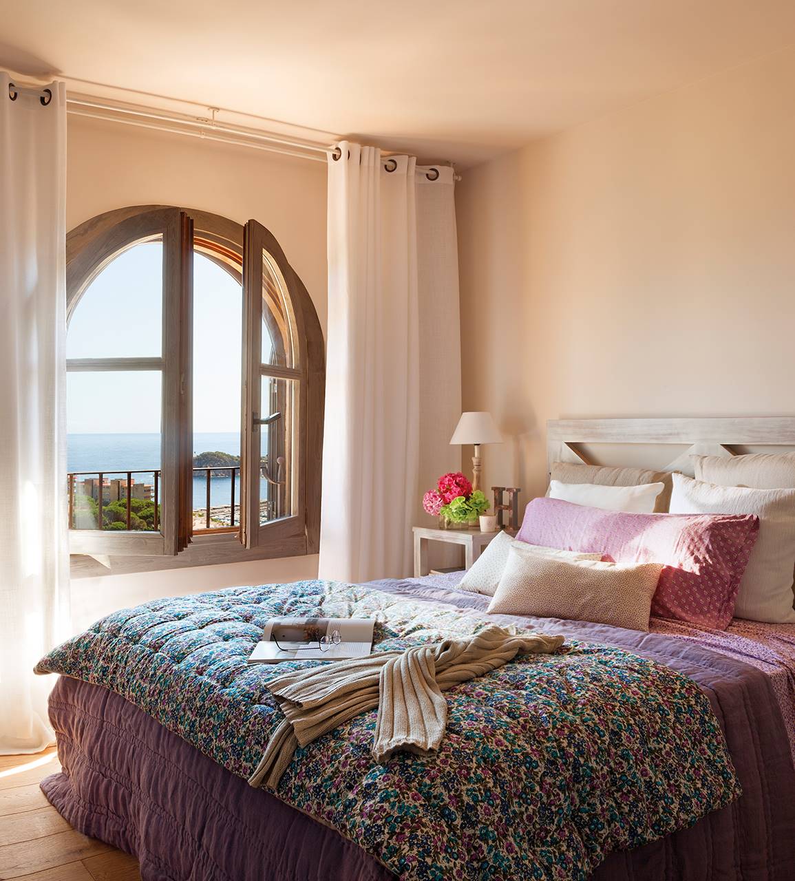 Dormitorio con ventana en arco y vistas al mar