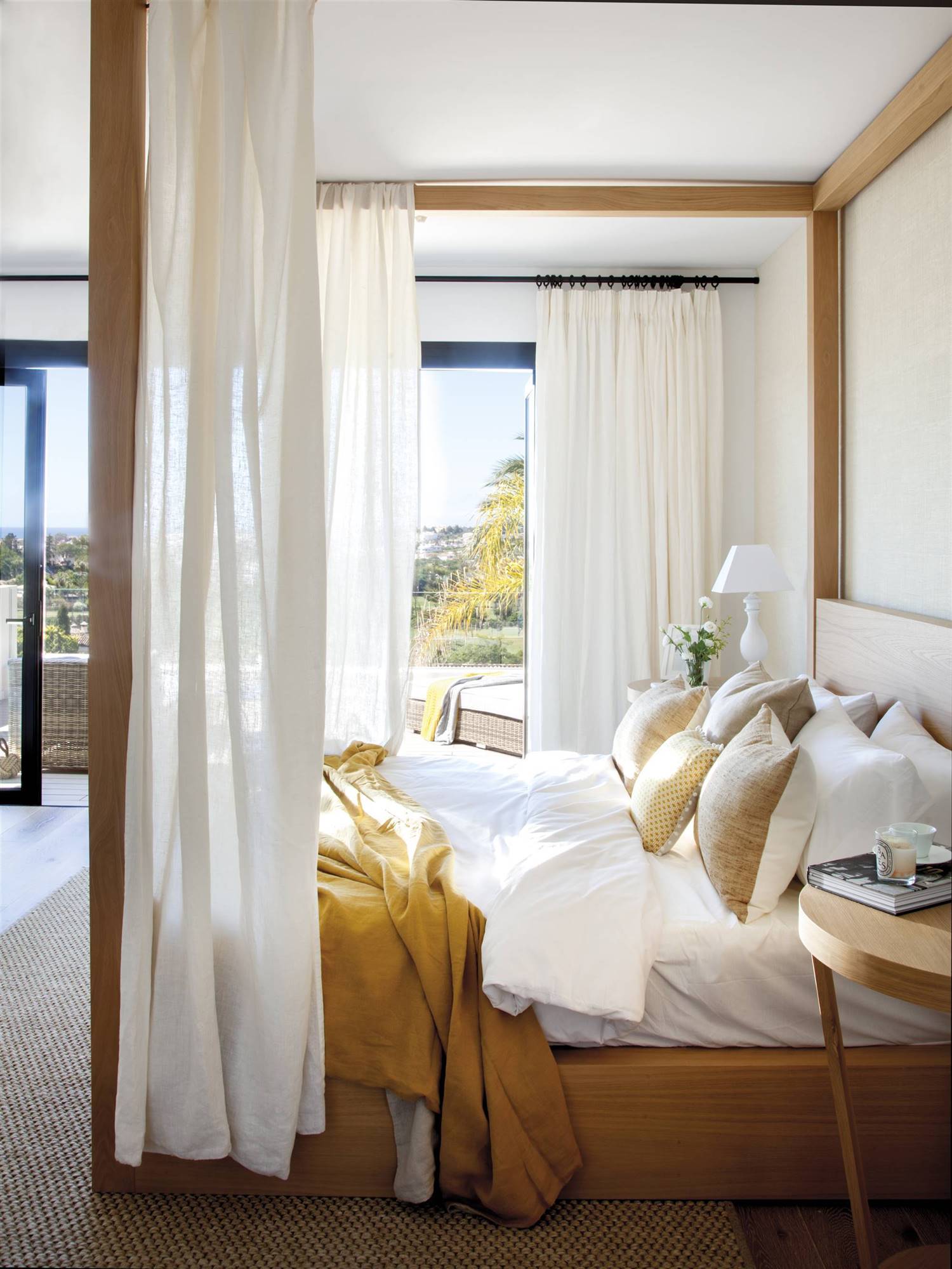 Dormitorio veraniego con largas cortinas en tonos blancos que consiguen crear un espacio muy armónico.