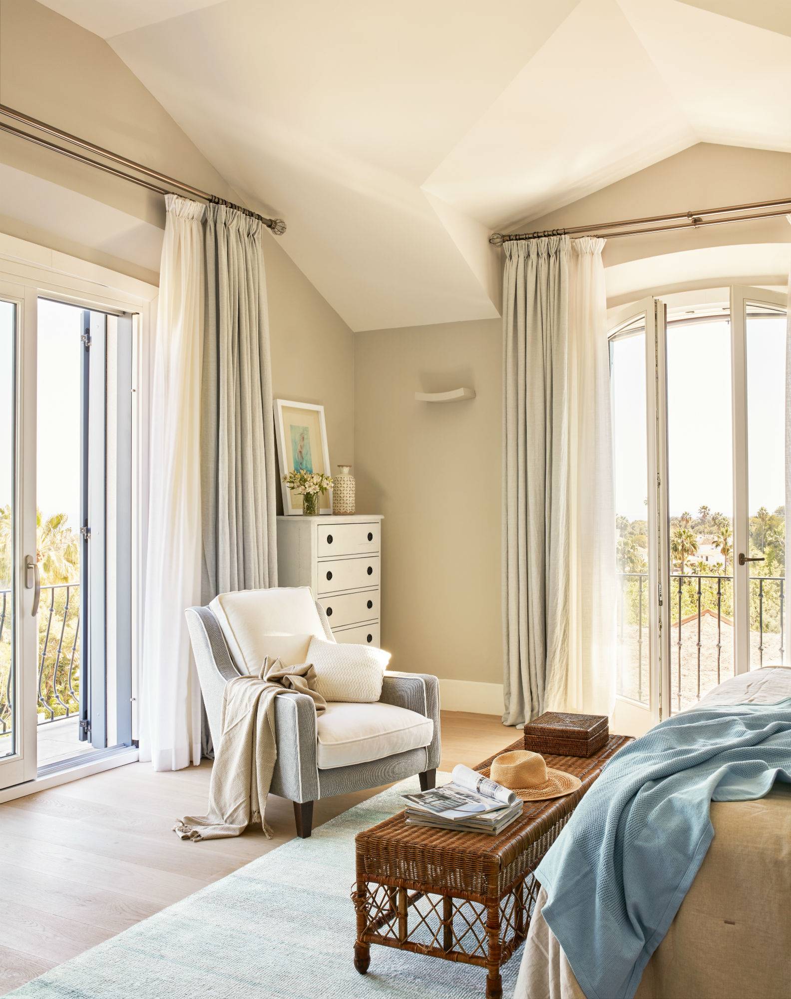 Dormitorio veraniego en Cádiz con muebles clásicos y detalles de fibras naturales.