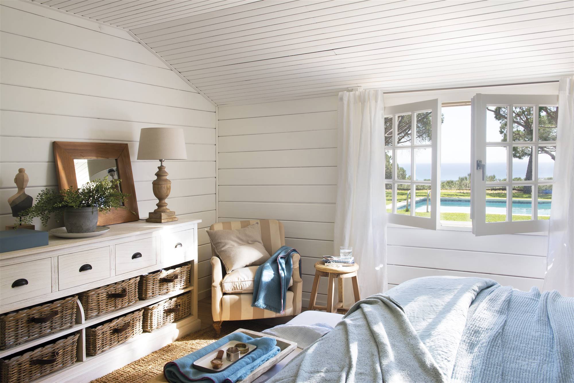 Dormitorio veraniego con techos bajos y con vistas al mar. 