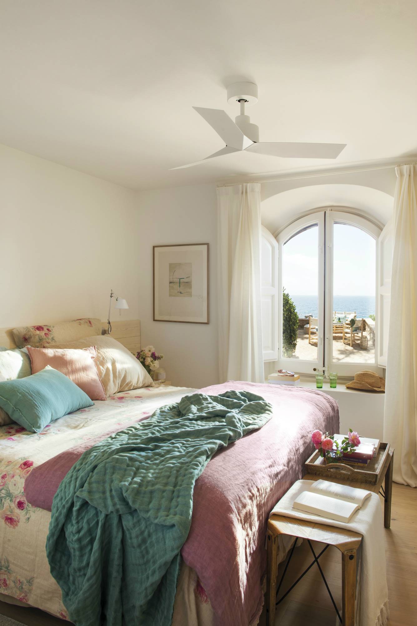 Dormitorio veraniego con estampado de flores combinado con textiles en verde azulado y lila