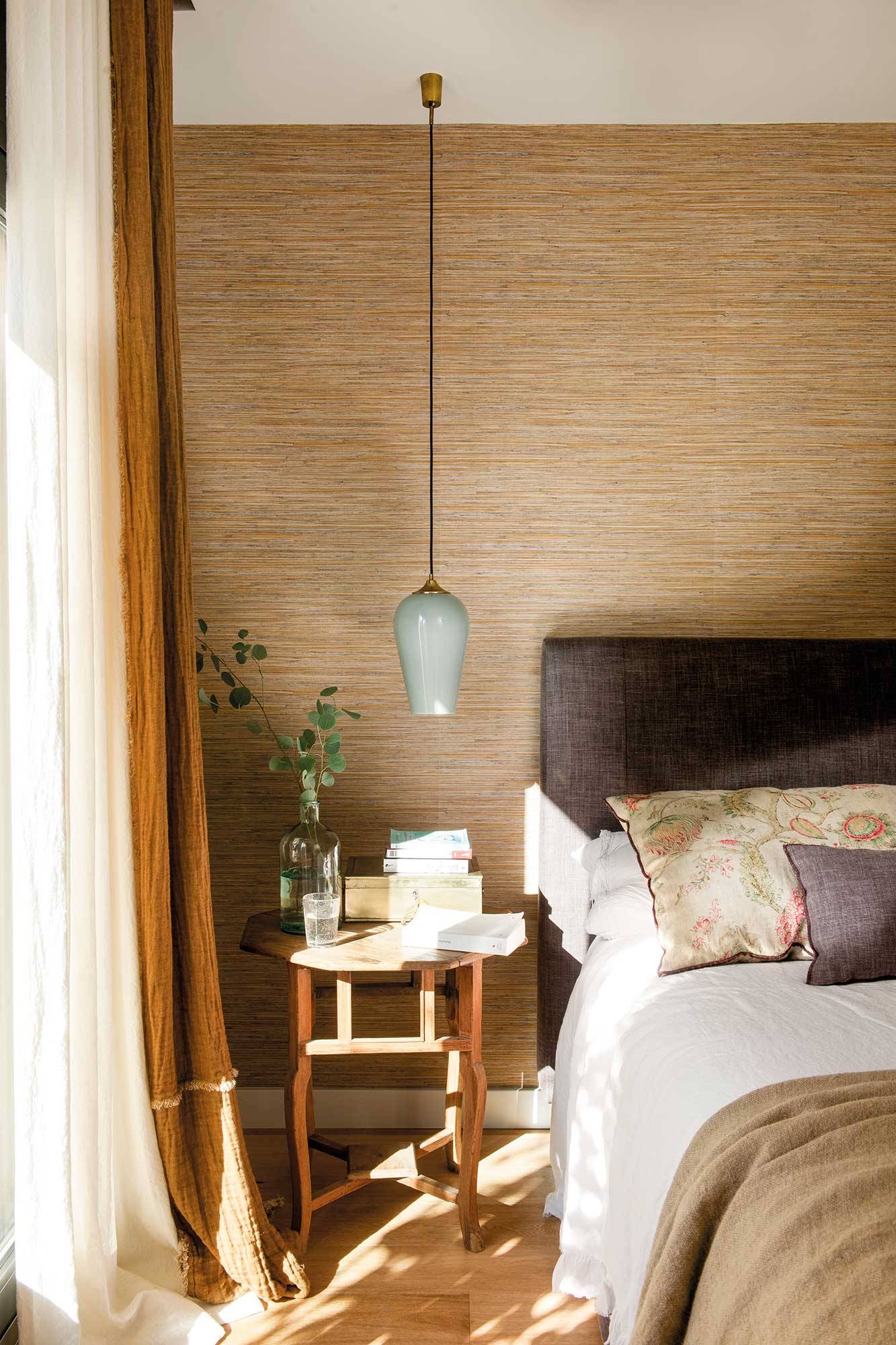 Dormitorio con pared del cabecero tapizada con papel pintado que imita las fibras naturales