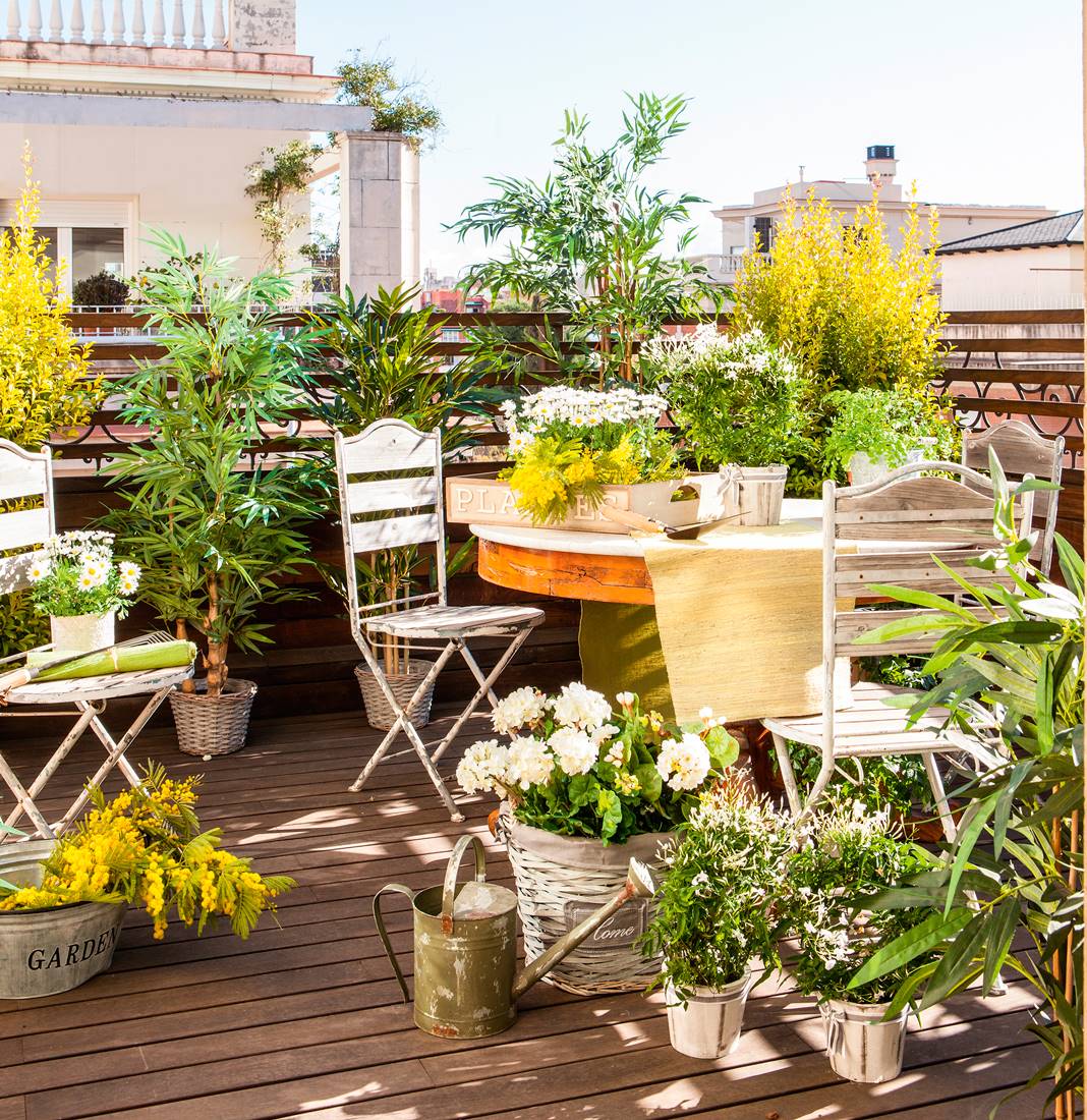 Terraza pequeña con suelo de tarima y sillas de jardín de estilo vintage. 