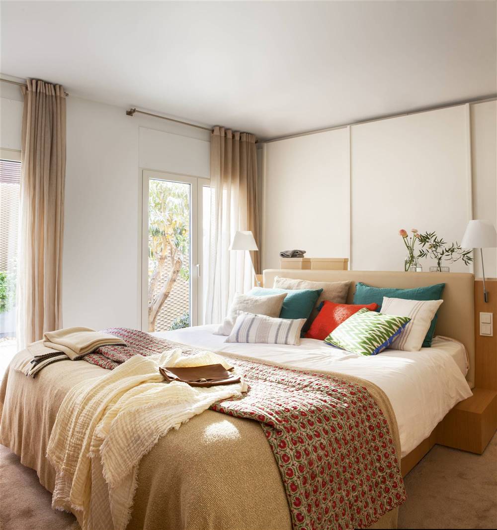 Dormitorio con cabecero tapizado y armario blanco empotrado en la pared 00426443