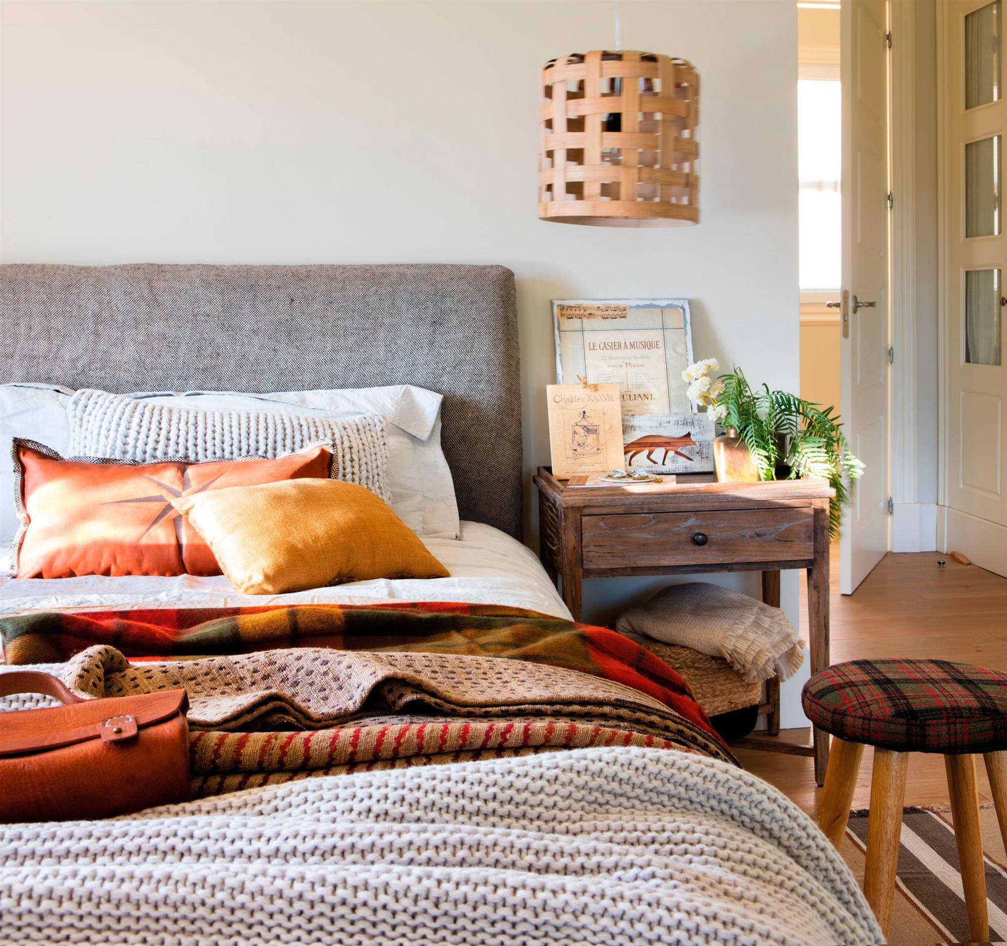 dormitorio-con-cabecero-tapizado-gris-y-lampara-de-techo. Renueva la paleta de color de tu casa