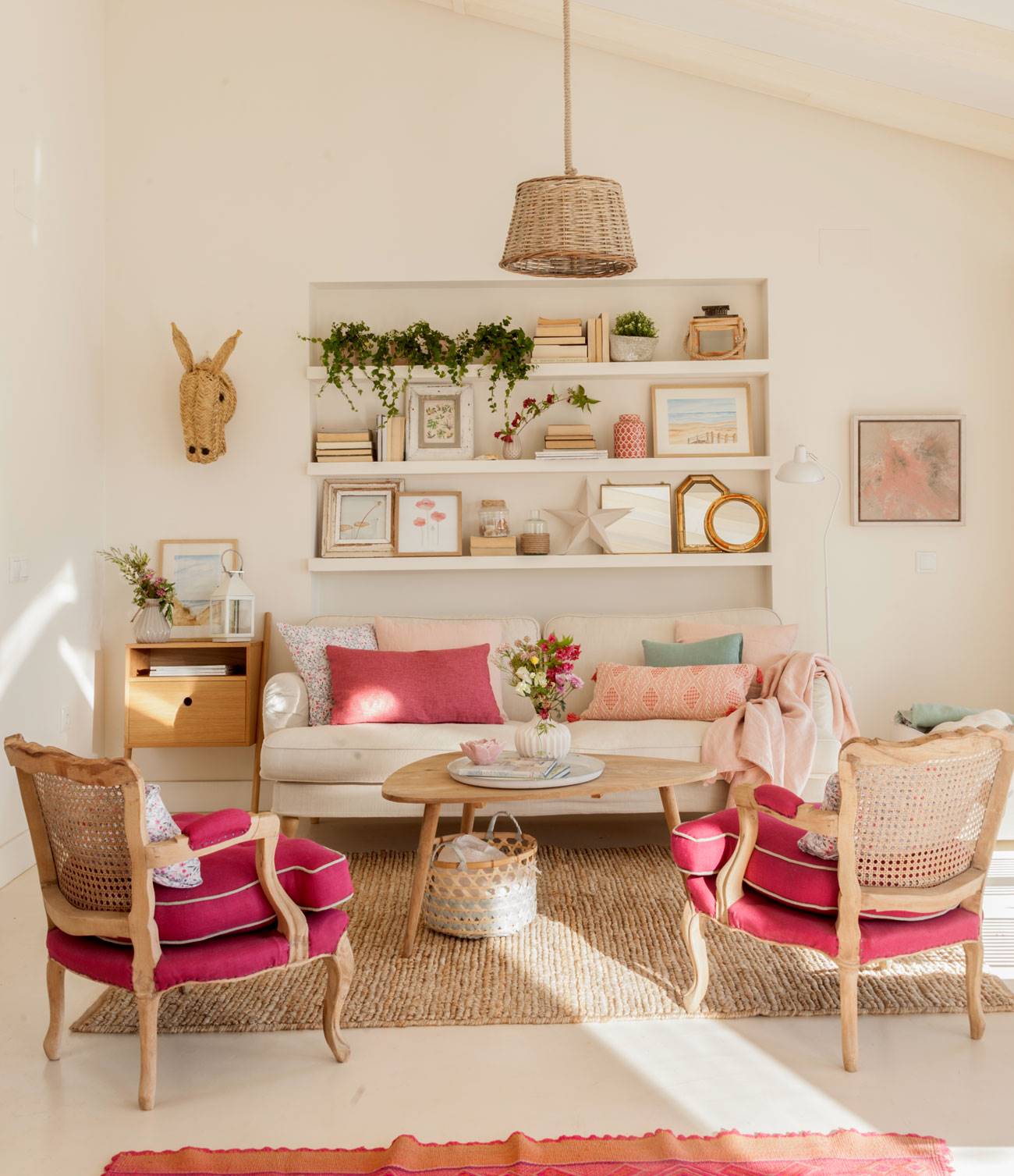 Salón con sofá beige y butacas de color rosa fucsia. 