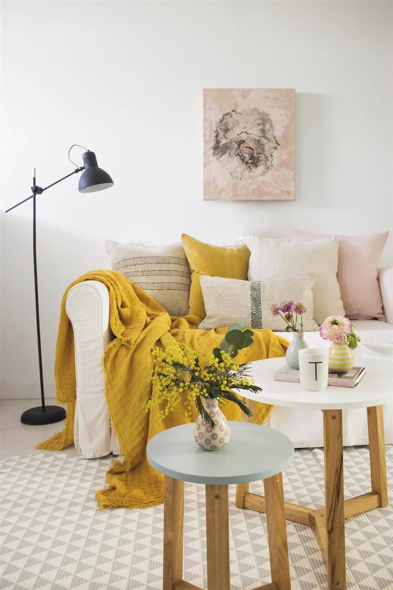 mesas-de-madera-de-colores-pastel-y-sofa-blanco-con-cojines-de-colores. Una pieza "con curvas", buena energía