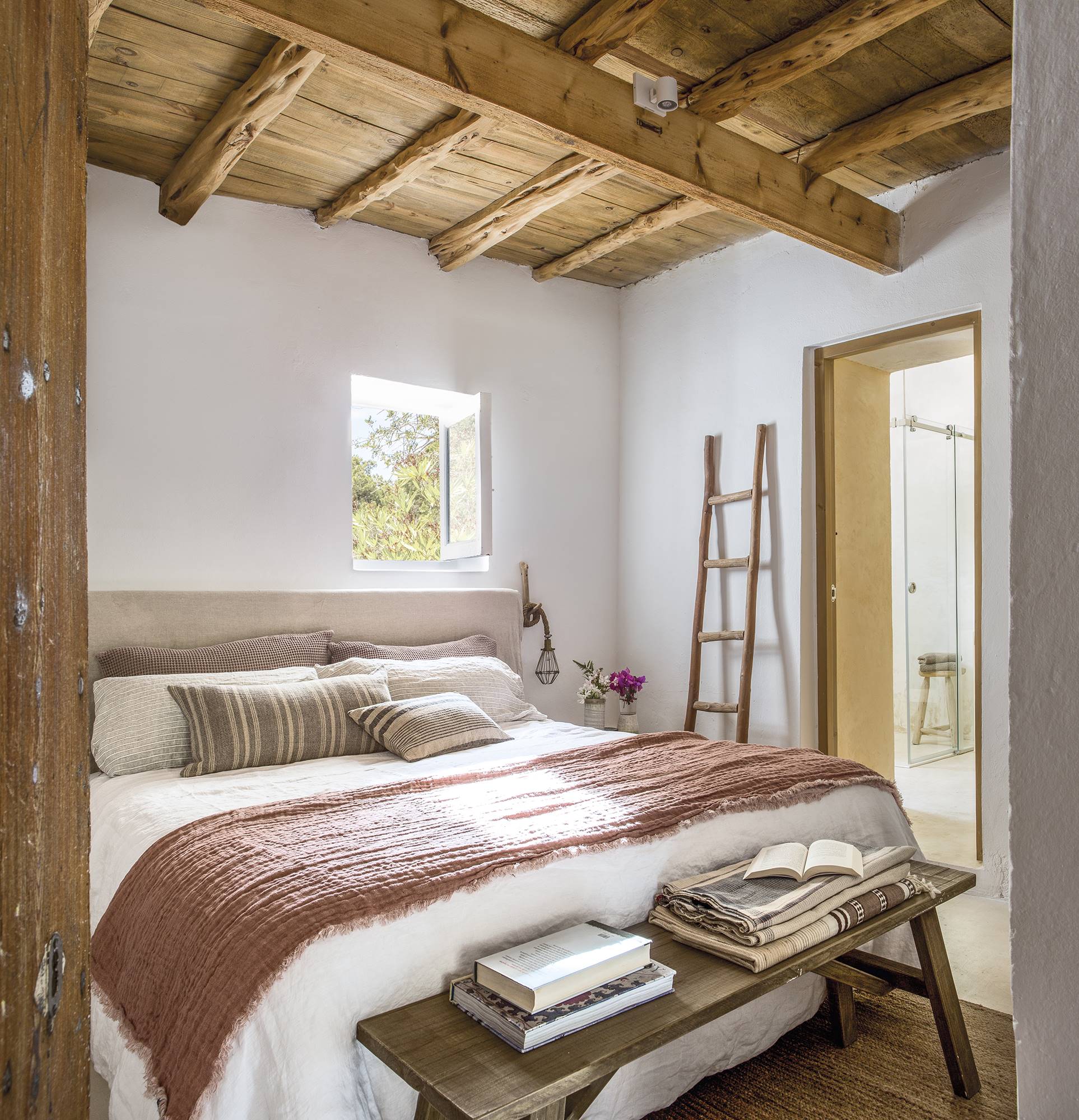 Dormitorio con techo con vigas de madera