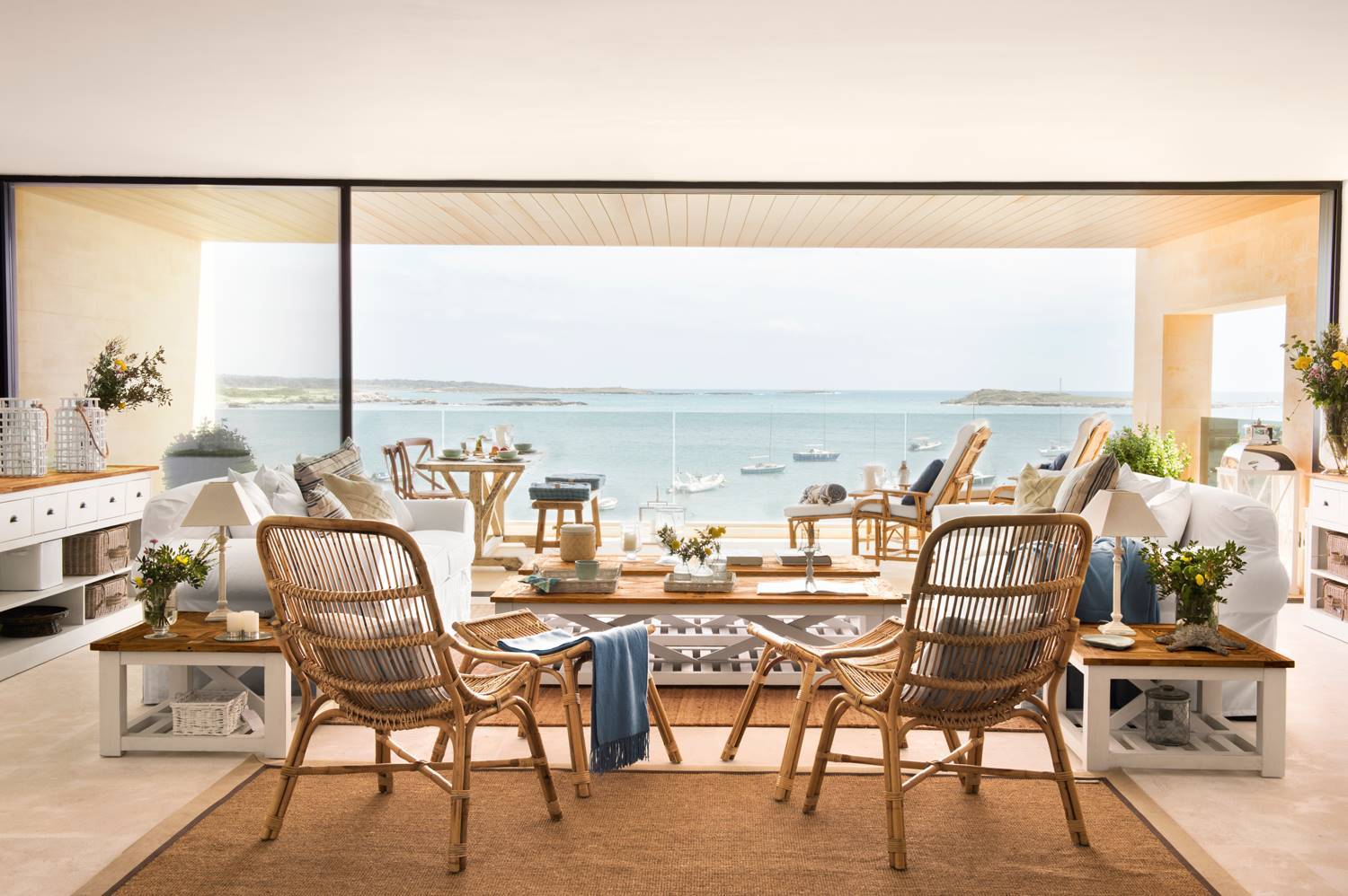 panoramica-de-salon-con-ventanal-con-vistas-al-mar-alfombra-de-fibra-sillas-de-cana-sofas-blancos-454170 4c4e8659 1500x998