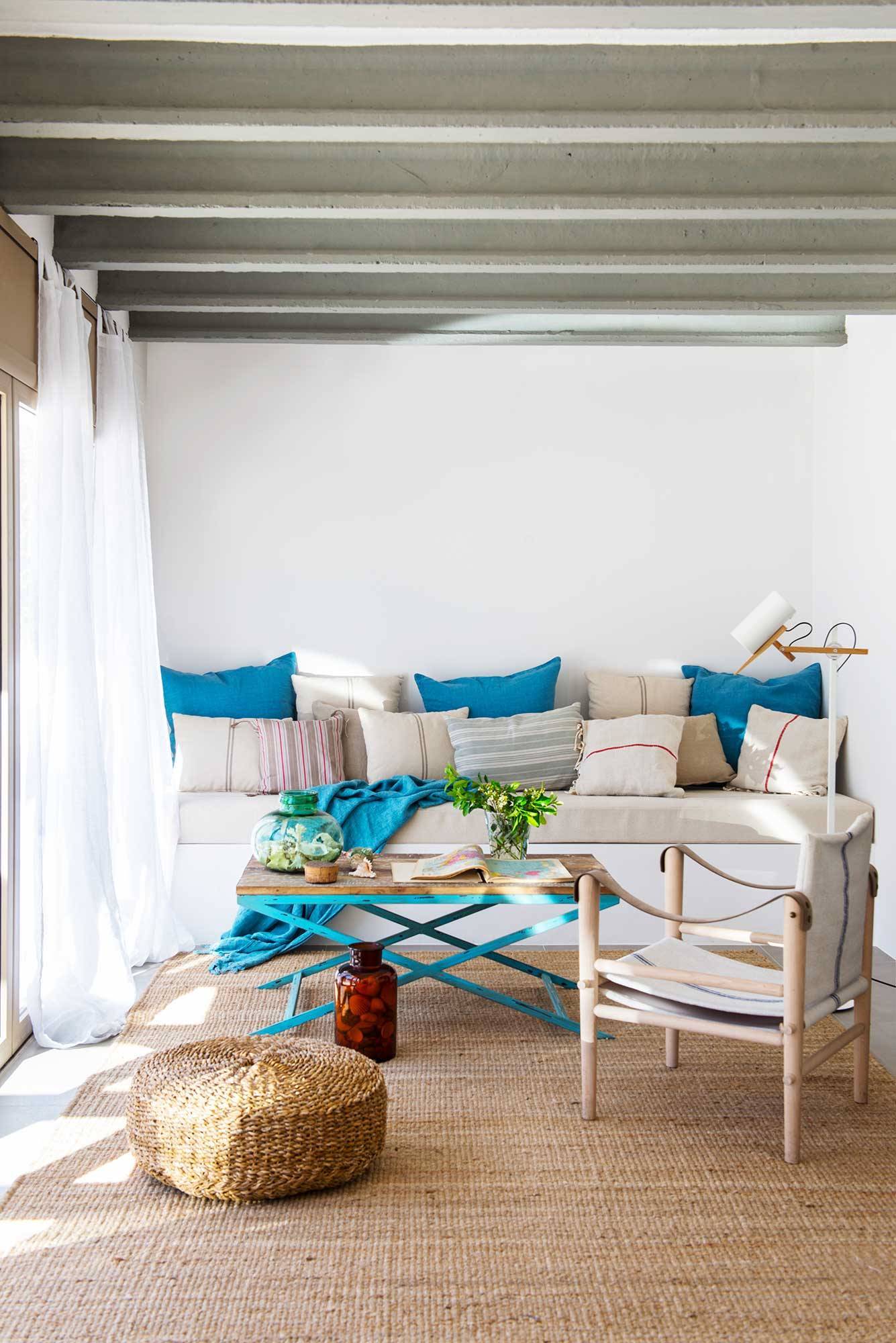 Salón con sofá blanco y cojines azules. 