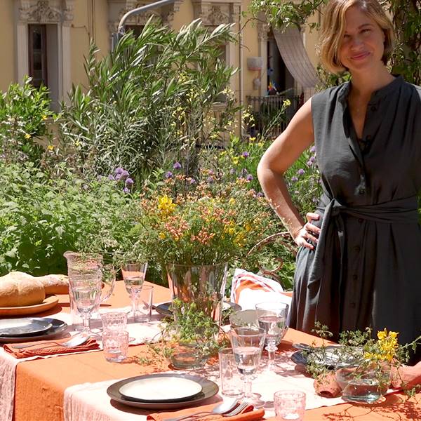 Martina Klein junto a una mesa en la terraza vestida con textiles, vajillas y complementos de Lo de Manuela