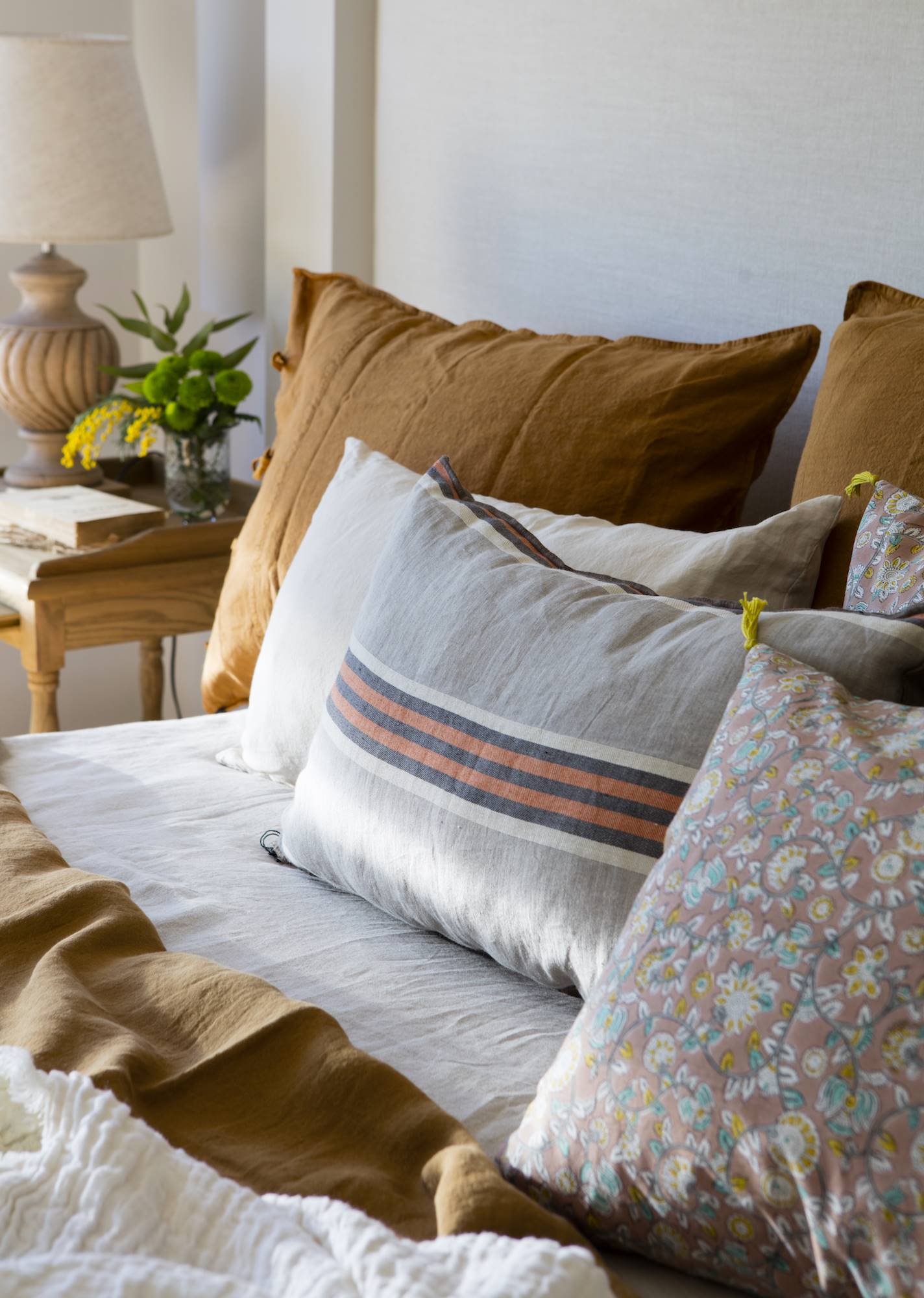 Combinación de cojines de cama estampados color canela.