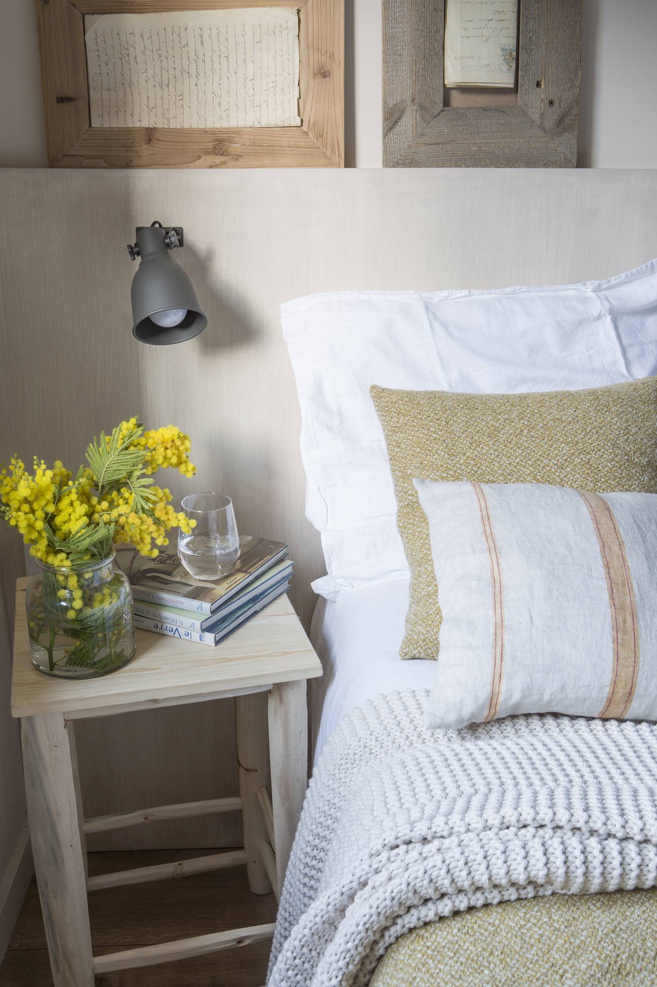 Detalle de un dormitorio con ropa blanca y beige.