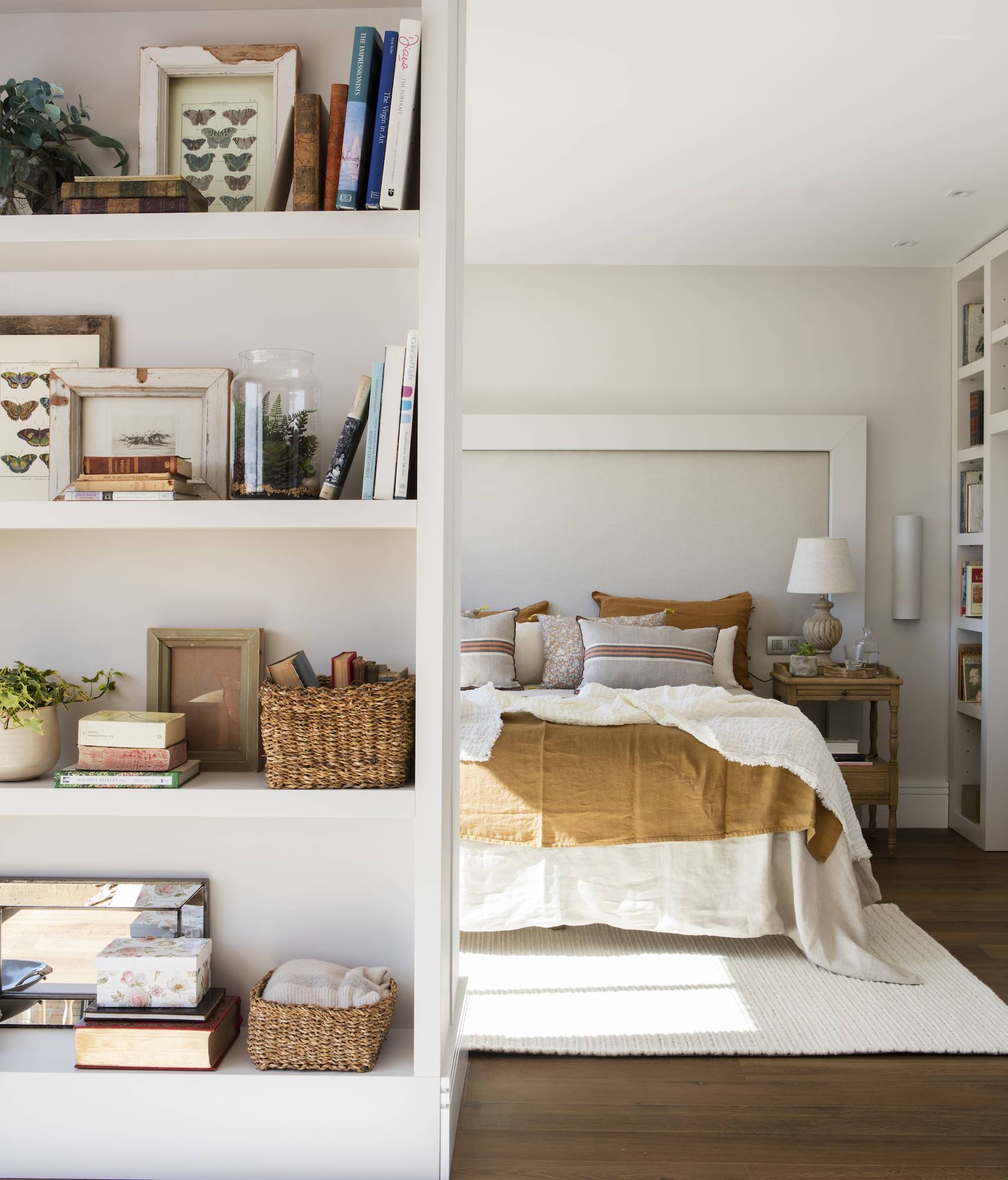 Dormitorio blanco con ropa de cama color tierra.