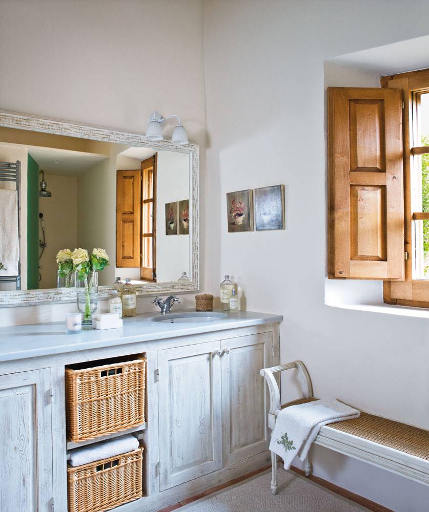 Baño con lavamanos doble y banco bajo la ventana de madera 00260946