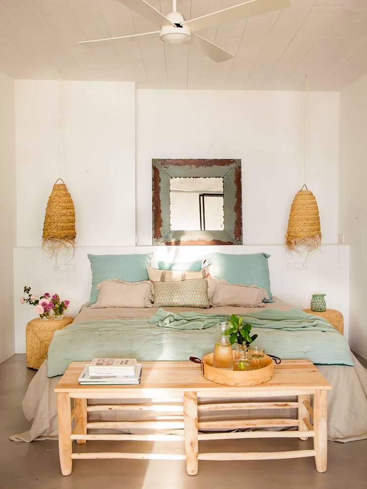 Dormitorio con banco en tonos azules y lámparas de fibras naturales.