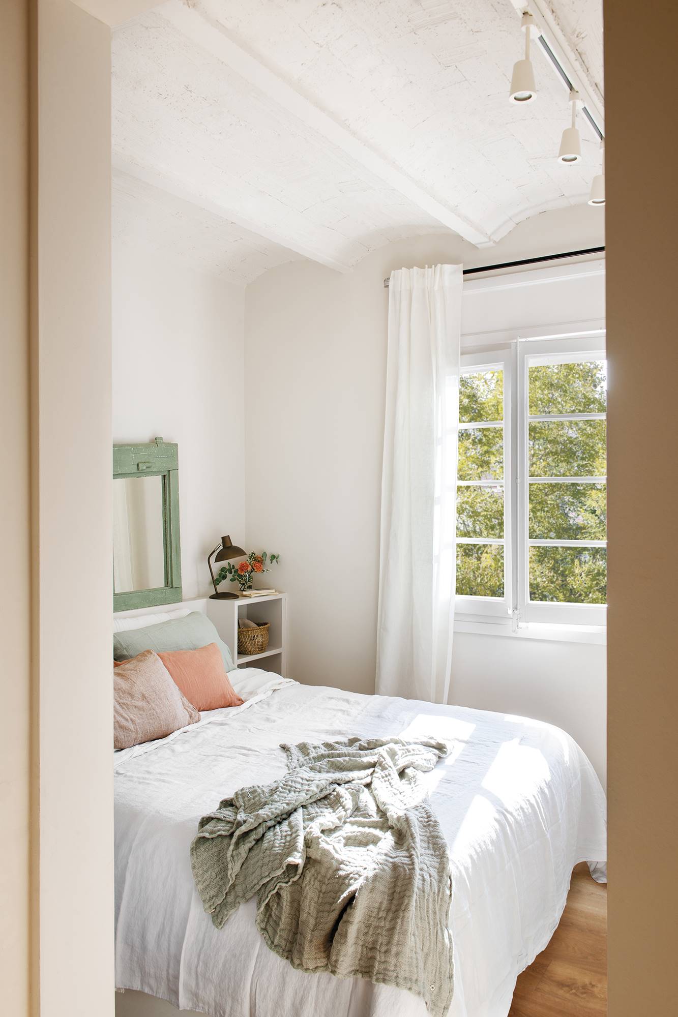 Dormitorio pequeño en blanco con cabecero y mesillas