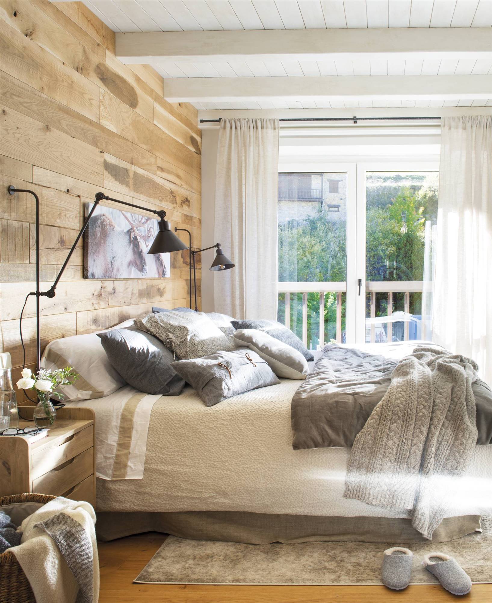 Dormitorio rústico moderno con pared de madera en el cabecero y apliques negros. 