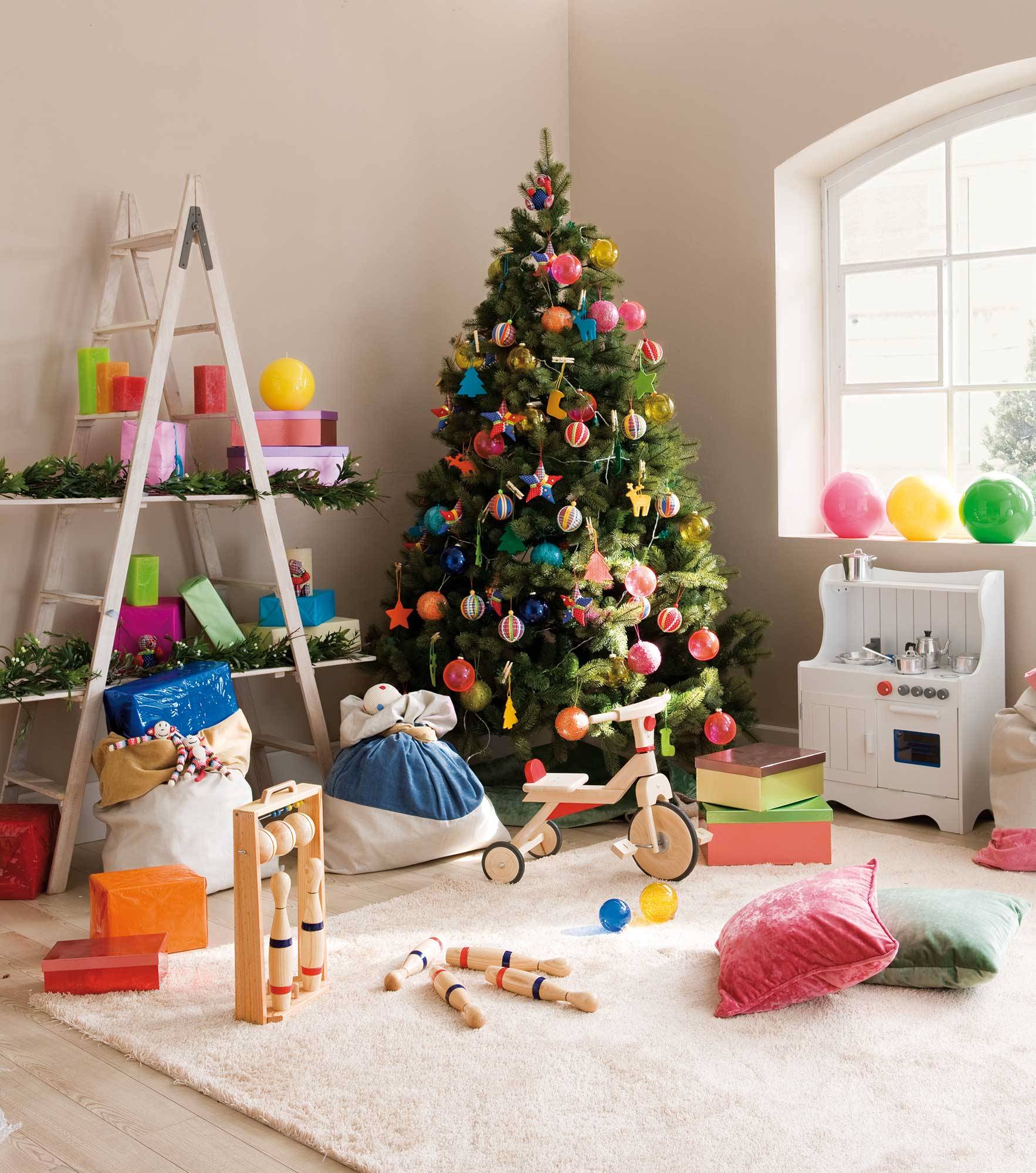 Salón infantil con juguetes para niños, estantería hecha a partir de una escalera vieja y árbol de Navidad con adornos divertidos multicolor. 