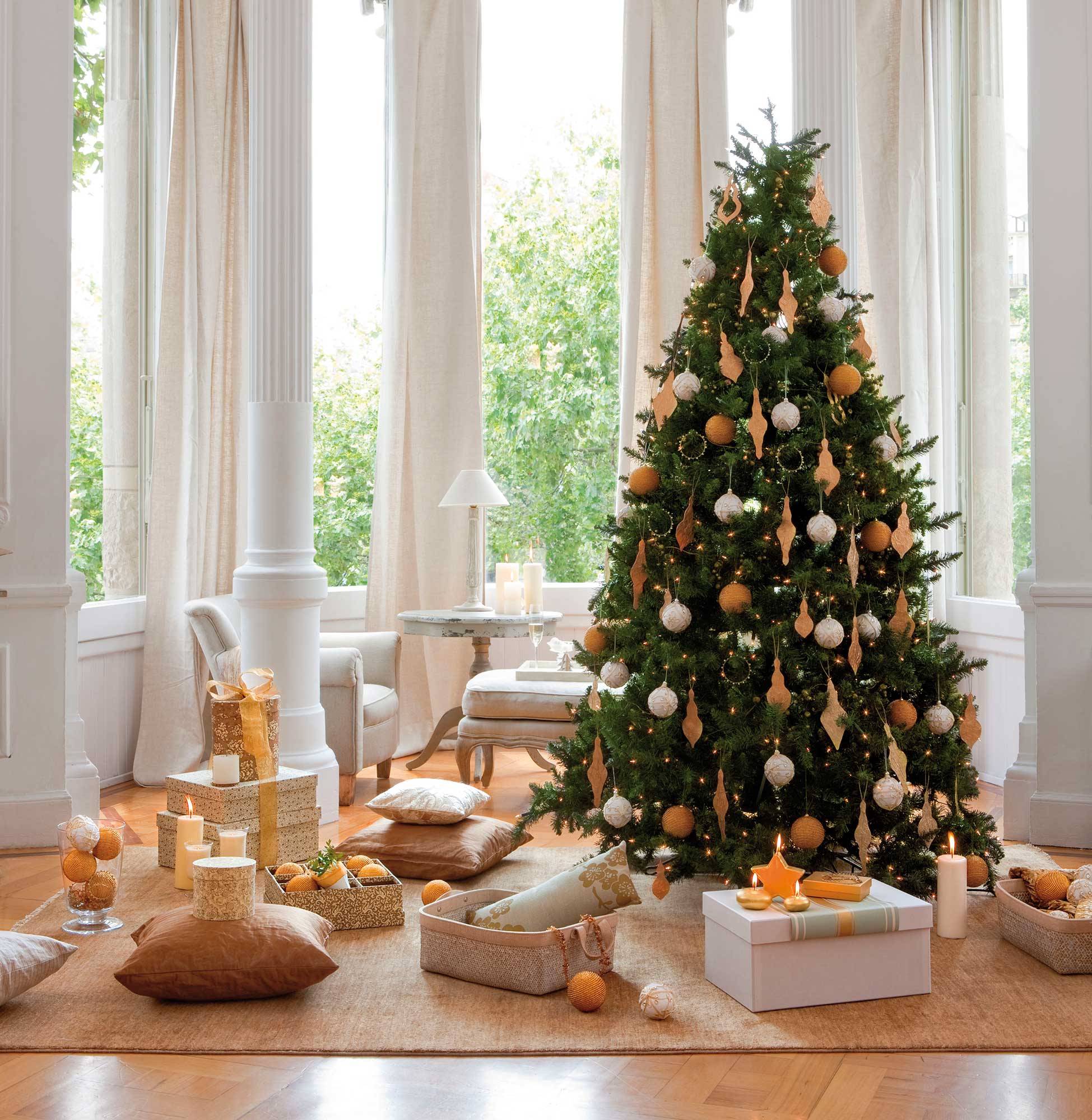 Salón blanco y clásico con árbol de Navidad decorado con bolas blancas y doradas.
