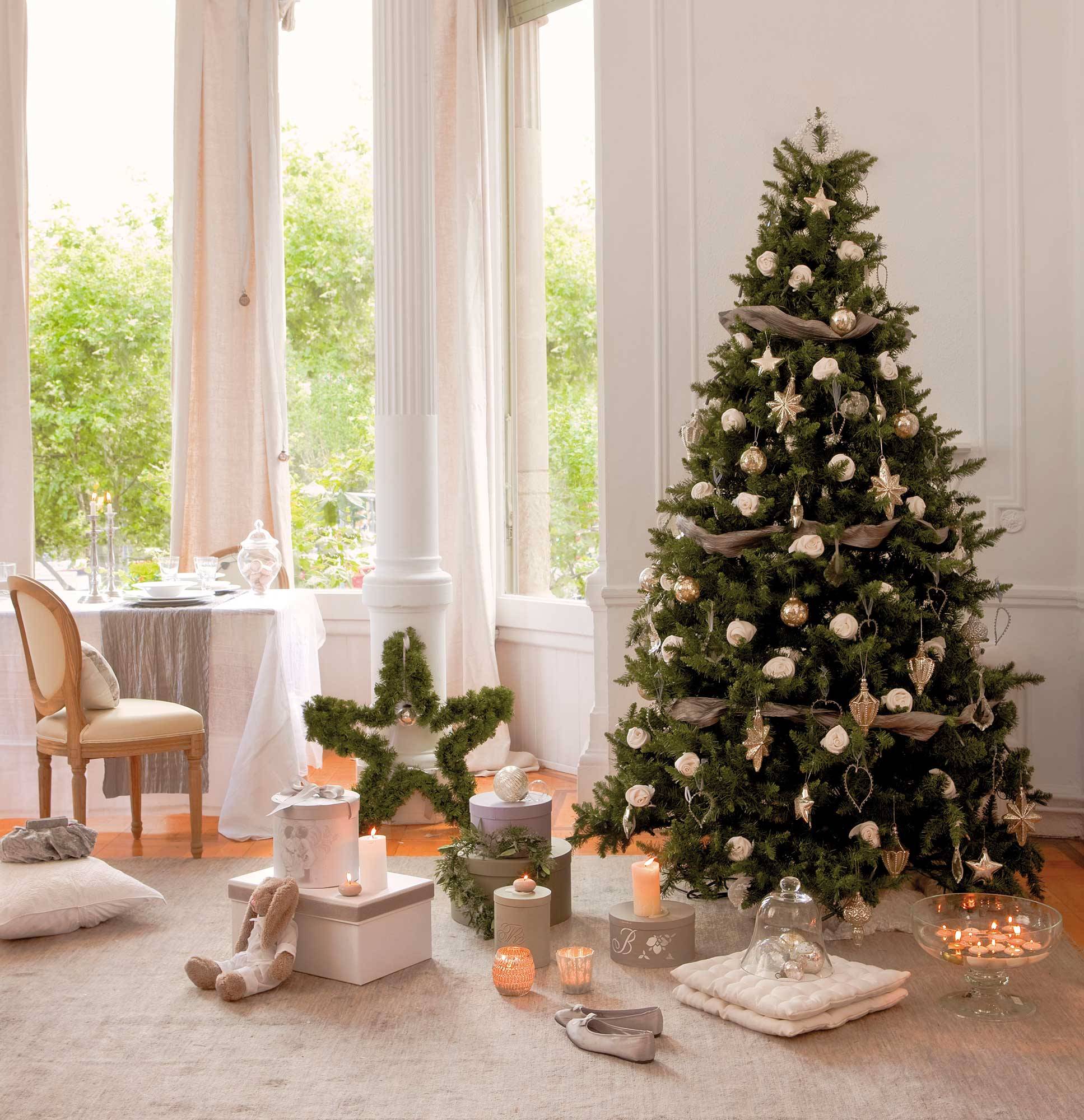 Comedor blanco y clásico con árbol de Navidad decorado con adornos plateados y rosas.