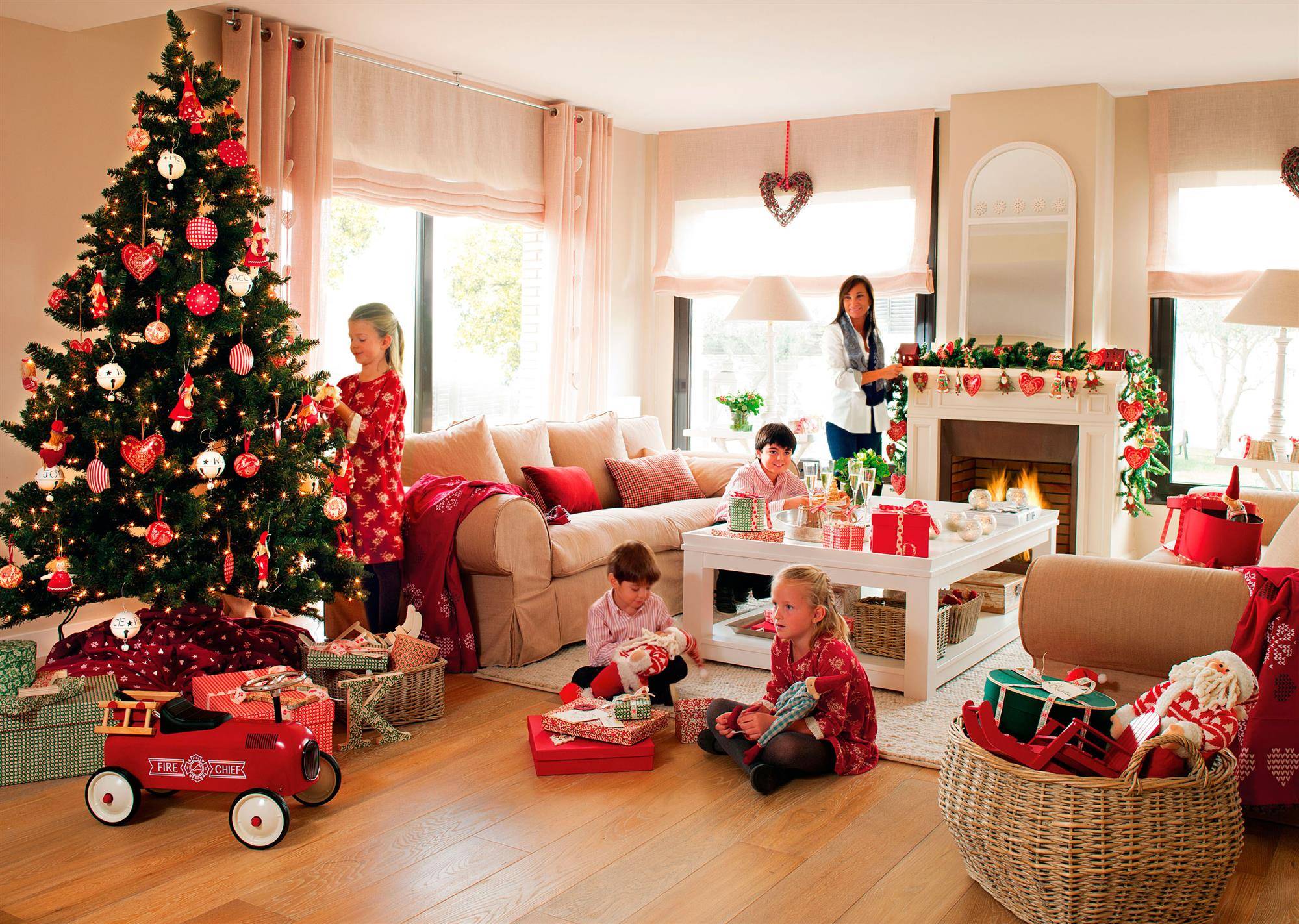 Salón navideño y familiar con chimenea, sofás beige y árbol de Navidad con detalles en rojo y blanco. 