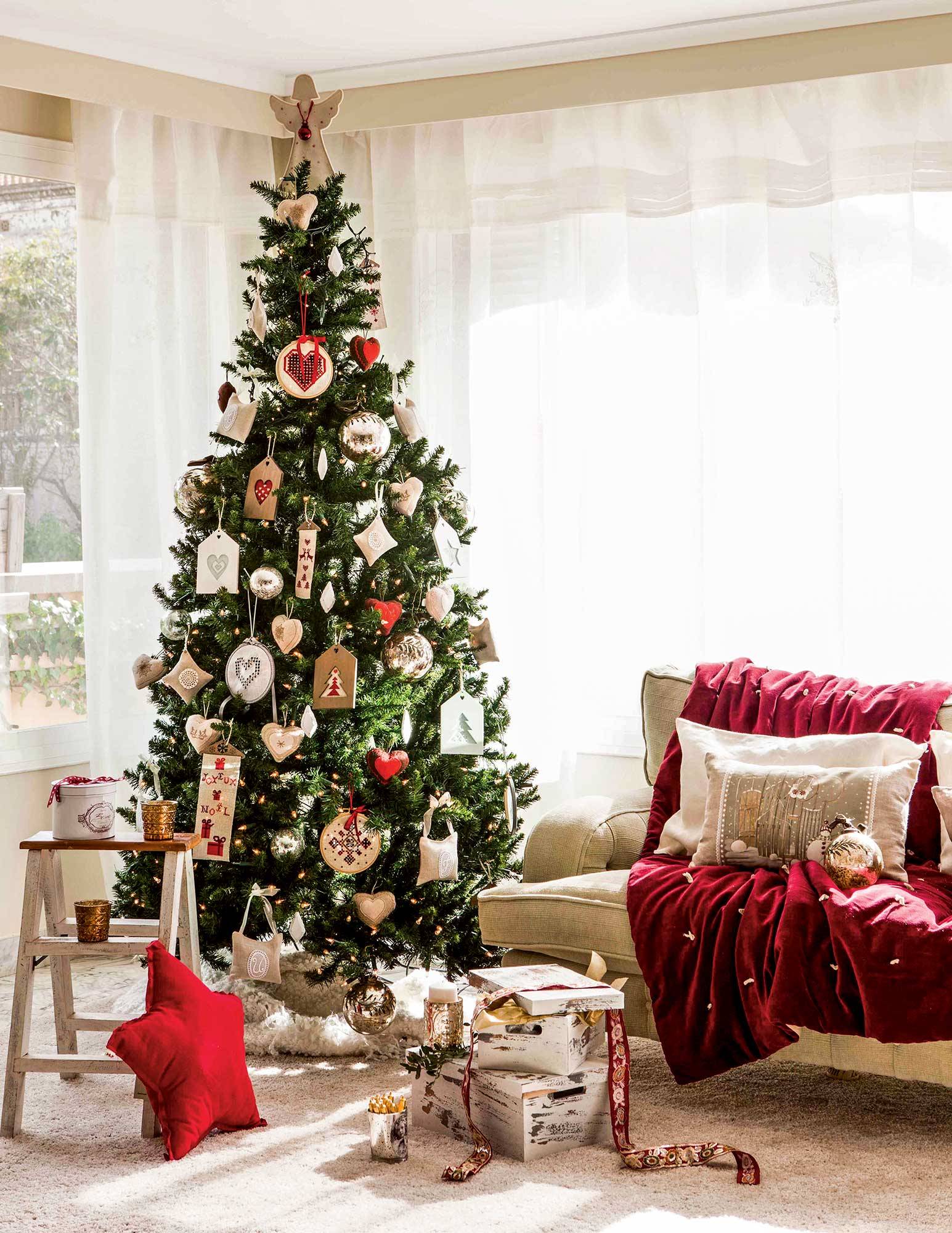Salón navideño con árbol de Navidad decorado con adornos con motivos bordados.  