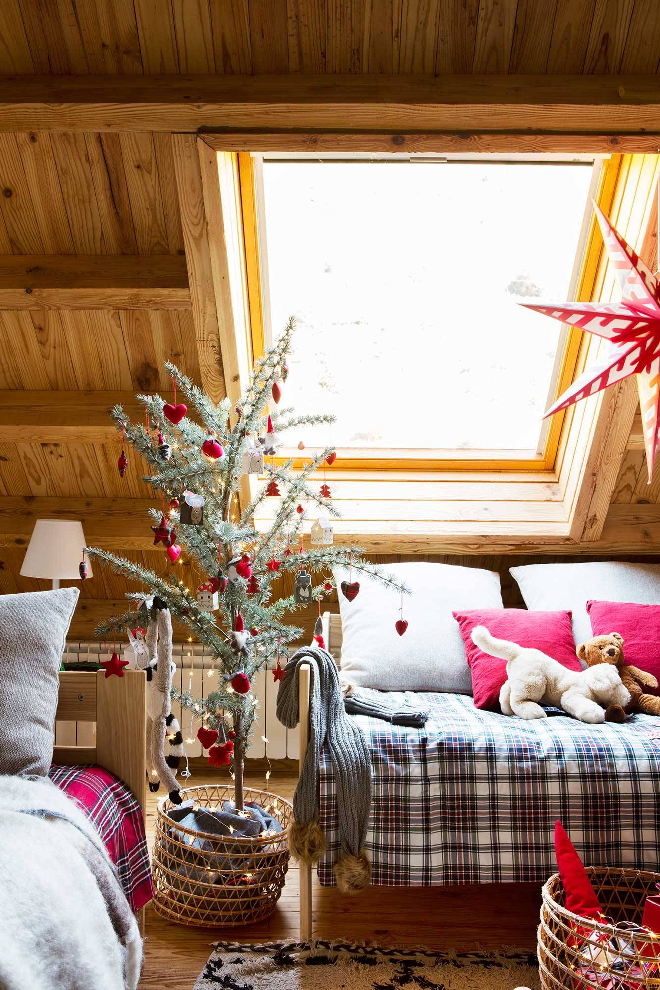 Dormitorio infantil rústico en buhardilla con un mini árbol de Navidad.