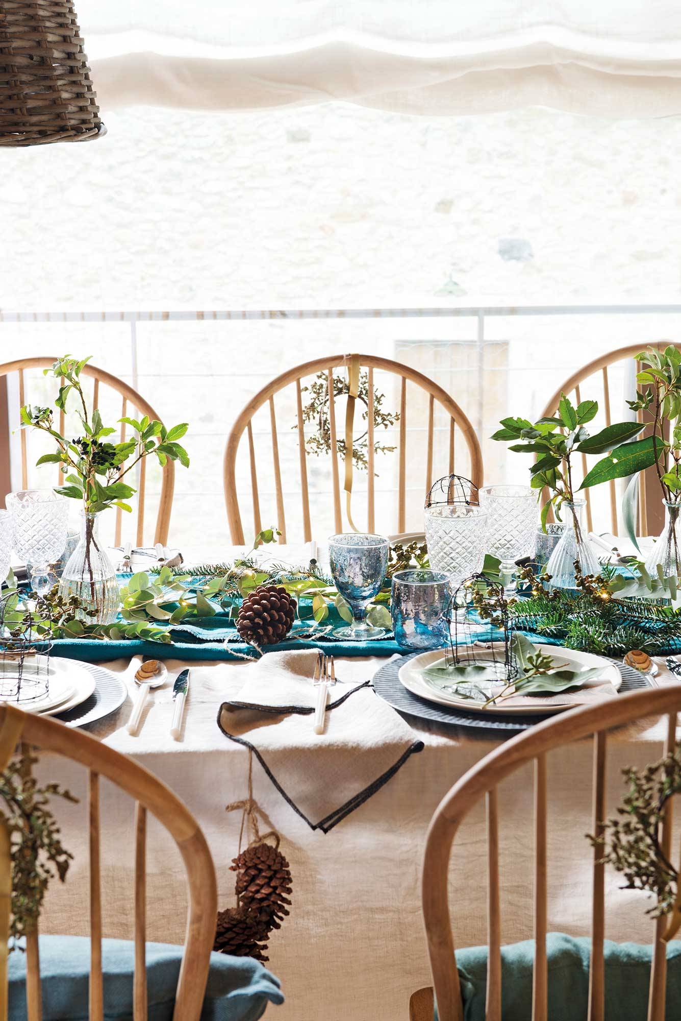 Mesa de navidad con centro de mesa de plantas.