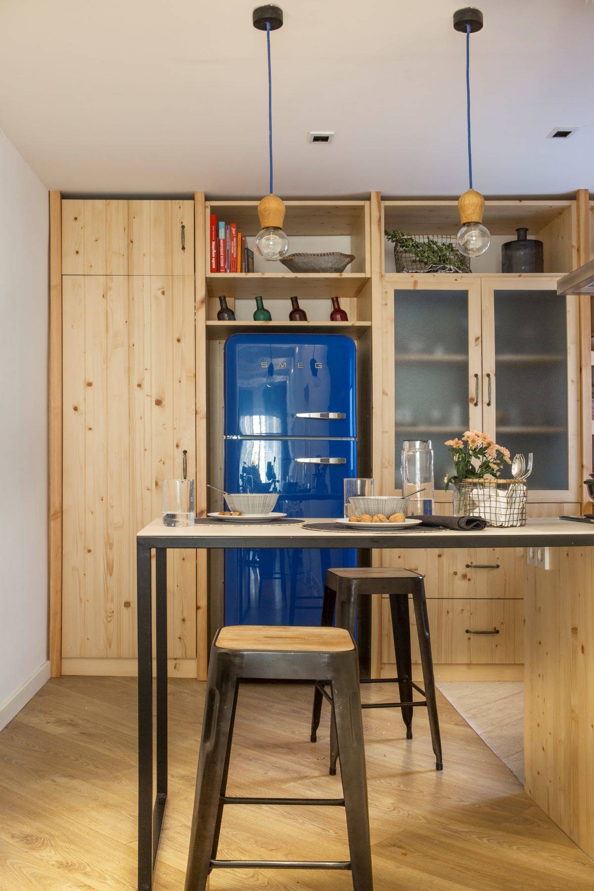 Cocina pequeña de madera con frigorífico azul. 
