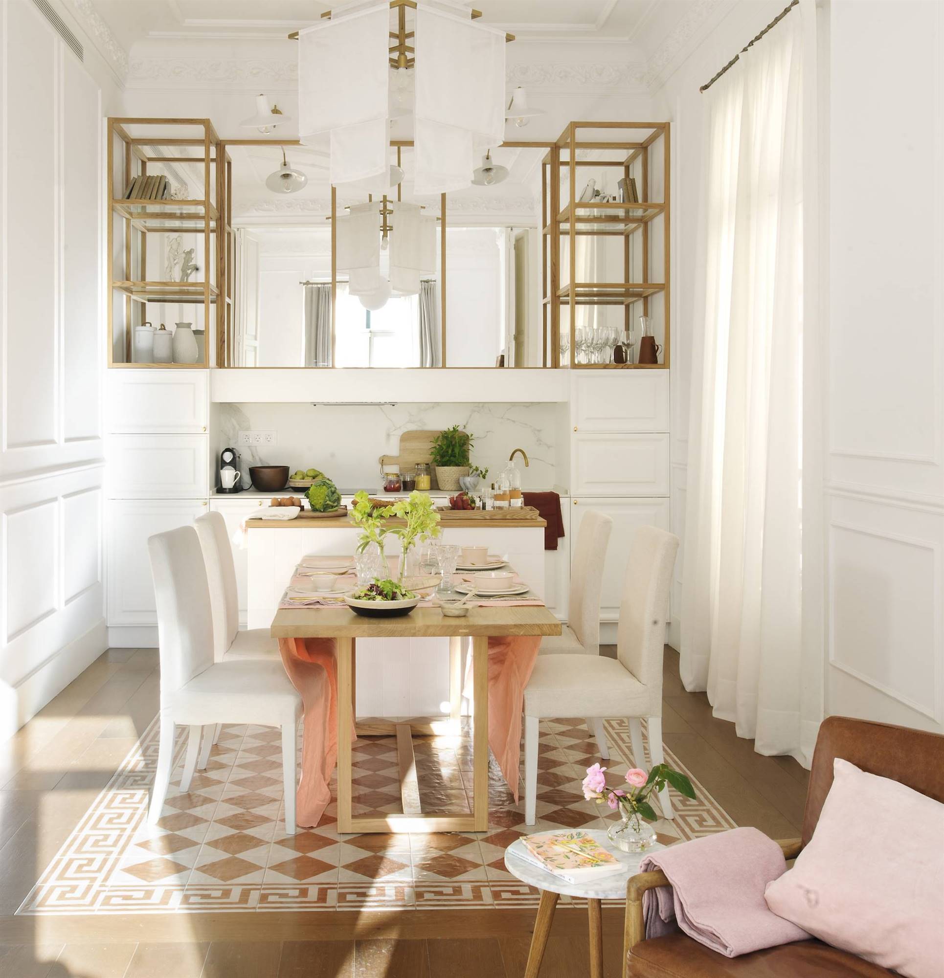 Comedor pequeño con mesa pegada a una cocina abierta de color blanco. 