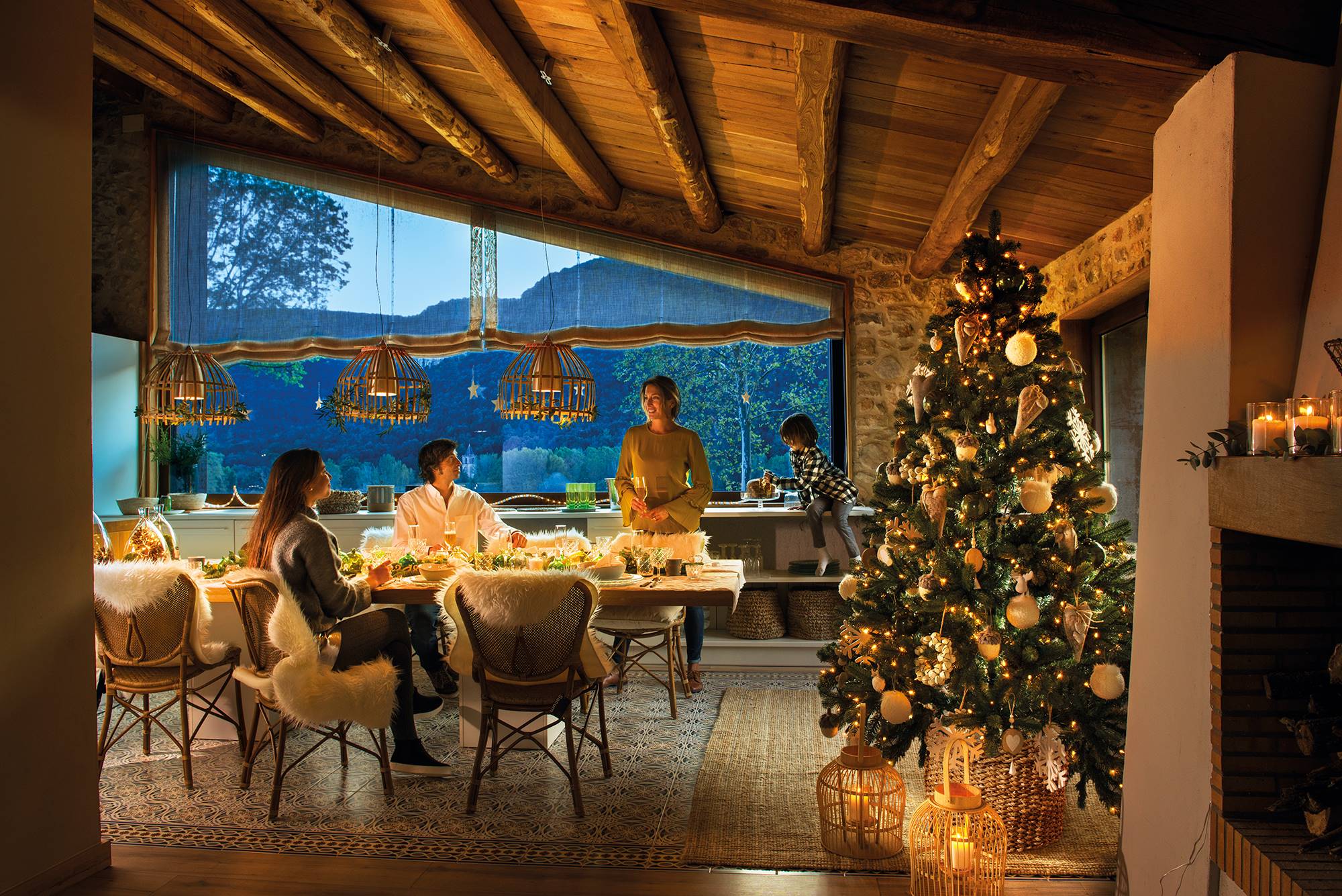 Comedor de casa de montaña decorado de Navidad con familia al atardecer