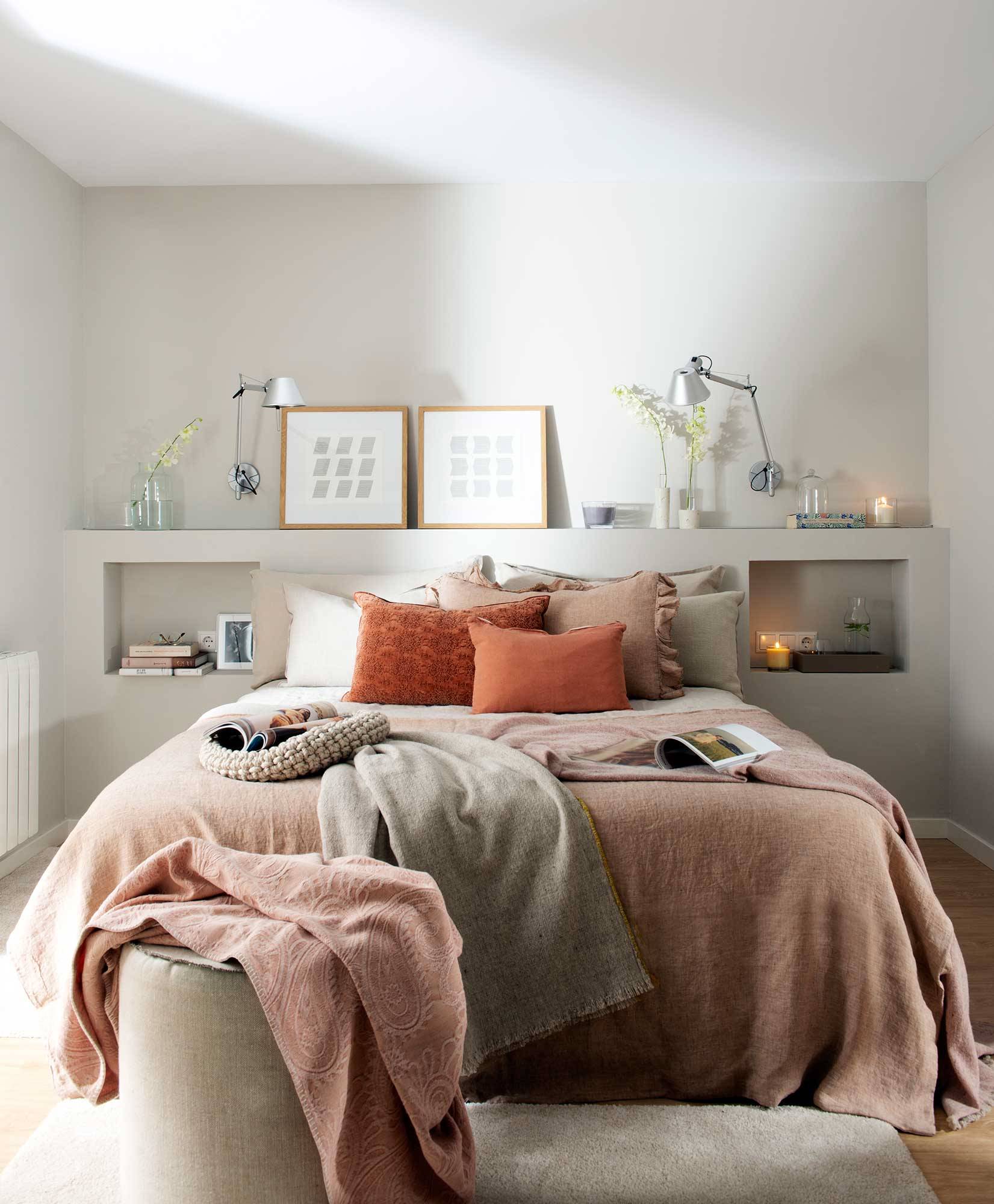 Dormitorio con cabecero de obra en blanco, mesillas integradas y ropa de cama en rosa empolvado.