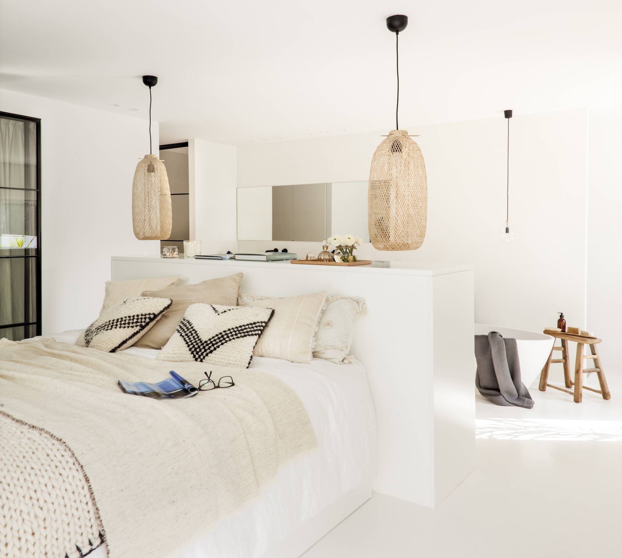 Dormitorio nórdico con baño abierto blanco y cabecero como elemento separador. 